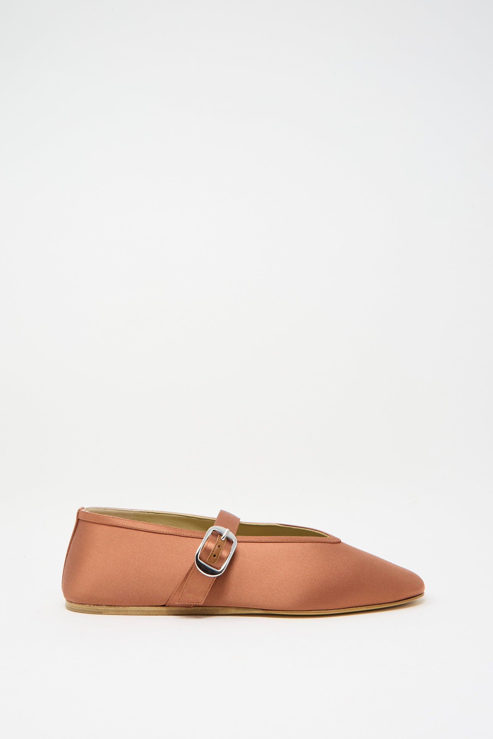 The Stretch Satin Stella Slipper in Rust by Le Monde Beryl, an Italian-sized brown flat shoe with a sleek side buckle, is showcased against a plain white background.