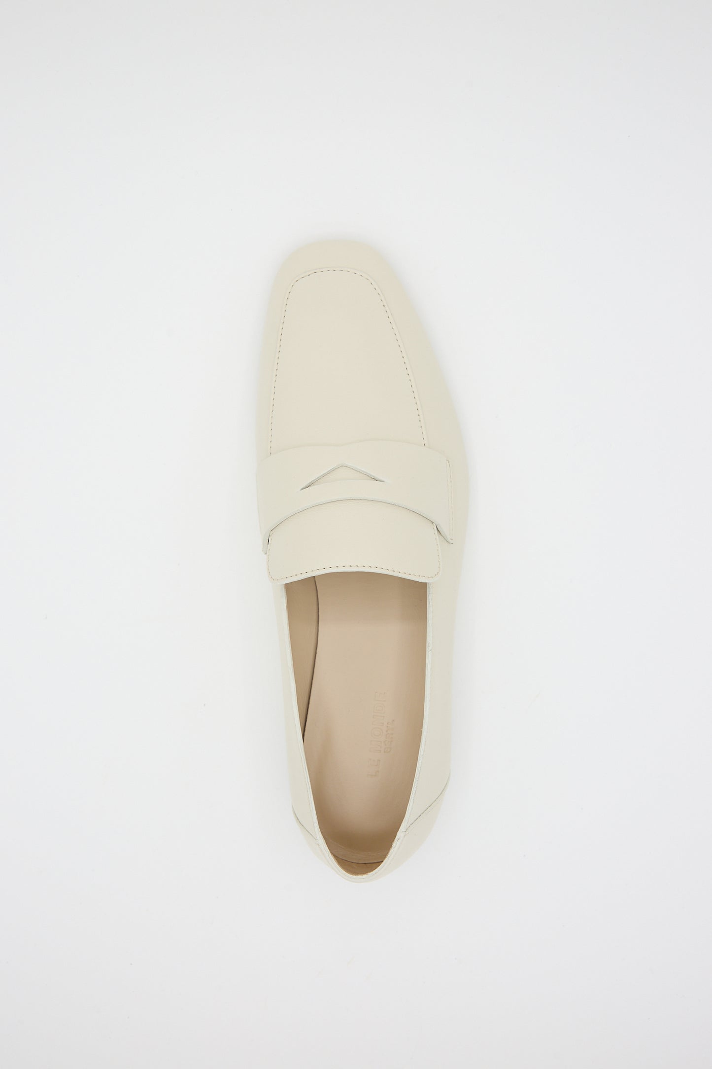 A single ecru Soft Loafer with Placket from Le Monde Beryl with a closed toe and a strap across the top is placed on a plain white background, featuring a cushioned insole for added comfort.