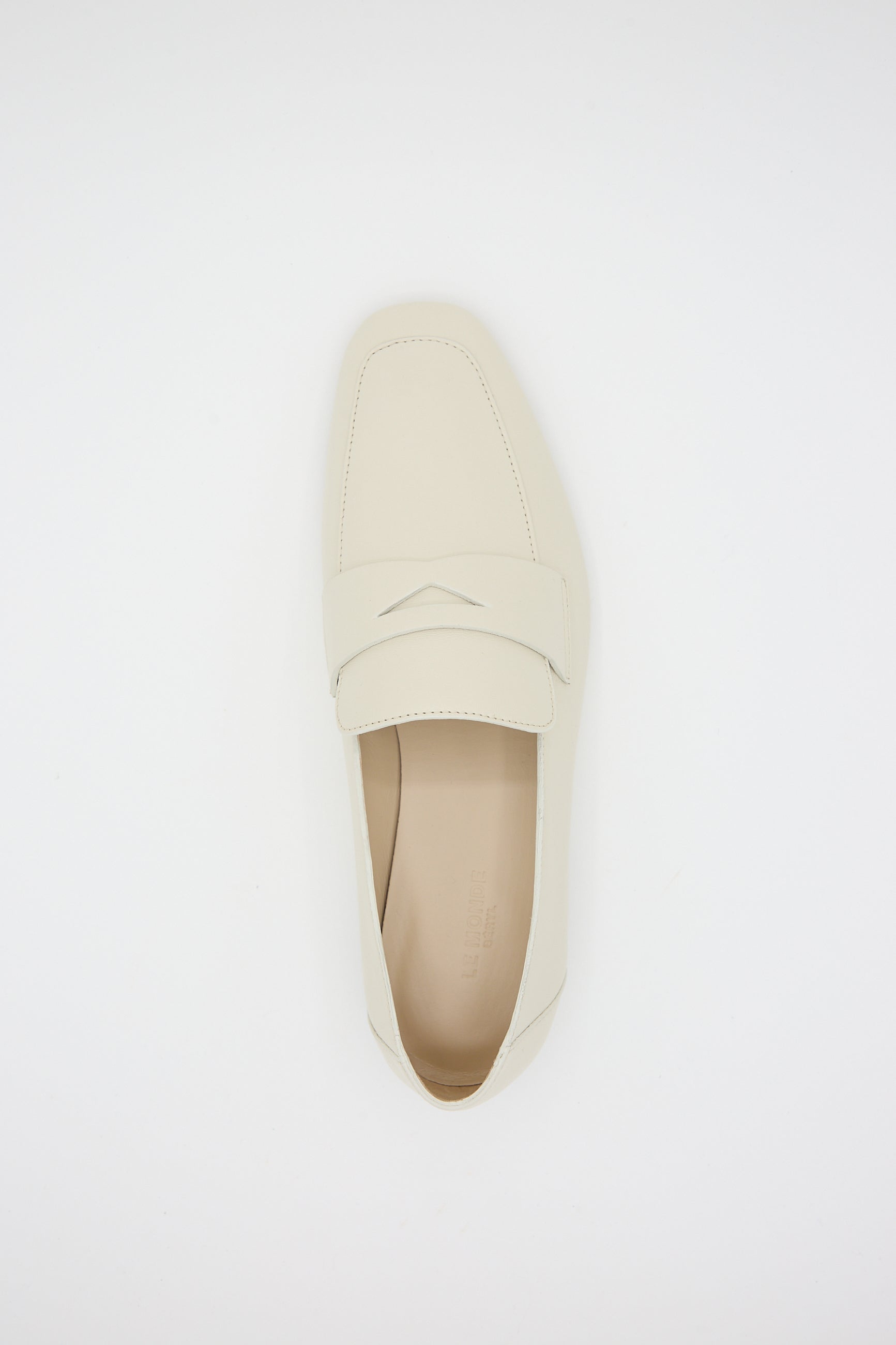 A single ecru Soft Loafer with Placket from Le Monde Beryl with a closed toe and a strap across the top is placed on a plain white background, featuring a cushioned insole for added comfort.