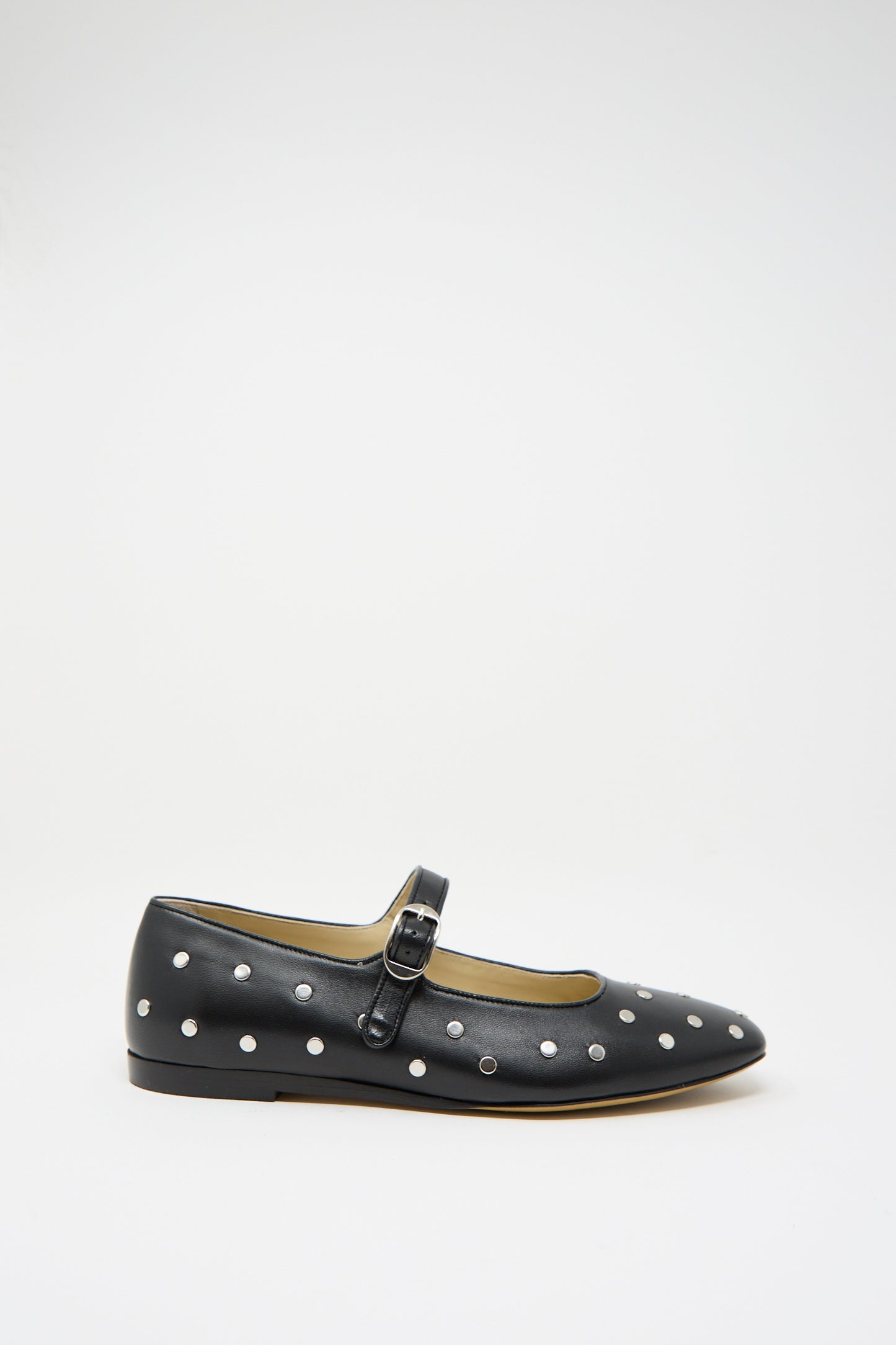 Le Monde Beryl's Studded Leather Mary Jane in Black is a black ballet flat adorned with polka dots, silver metal studs, and a small buckle strap against a white background.