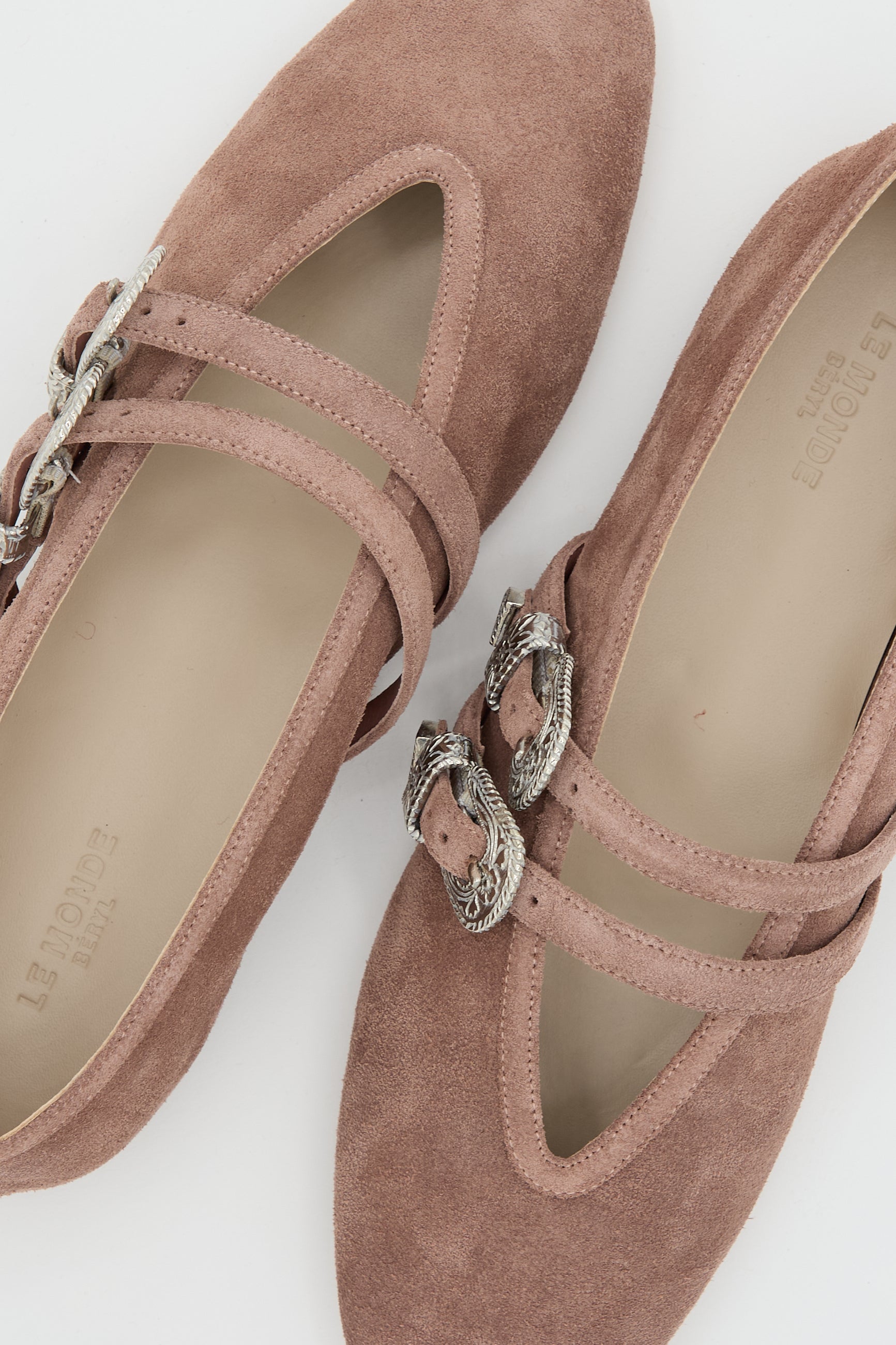 The Le Monde Beryl Suede Ballet Claudia Slipper in Pink is a pair of flats inspired by ballet slippers, made from suede, and accented with two straps featuring silver snake-shaped buckles.