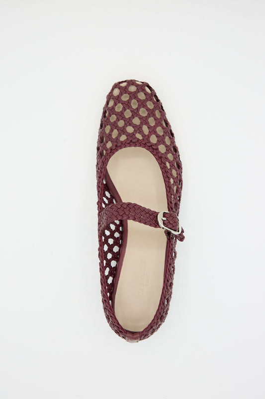 Red handwoven goatskin leather flat shoe on a white background.