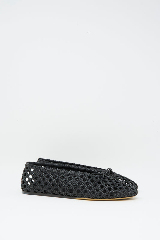 The Le Monde Beryl Woven Leather Regency Slipper in Black is a handwoven goatskin slipper with a cushioned calf leather insole, thin sole, and bow detail, shown against a plain white background.