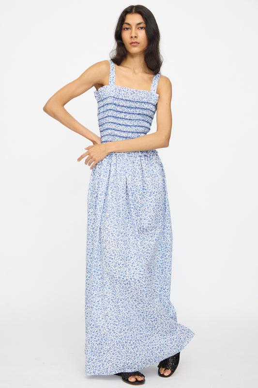 A person wears the Loretta Caponi Ombretta Dress in Marina Grande, a blue and white floral printed cotton sleeveless maxi dress made in Italy, standing against a plain white background.