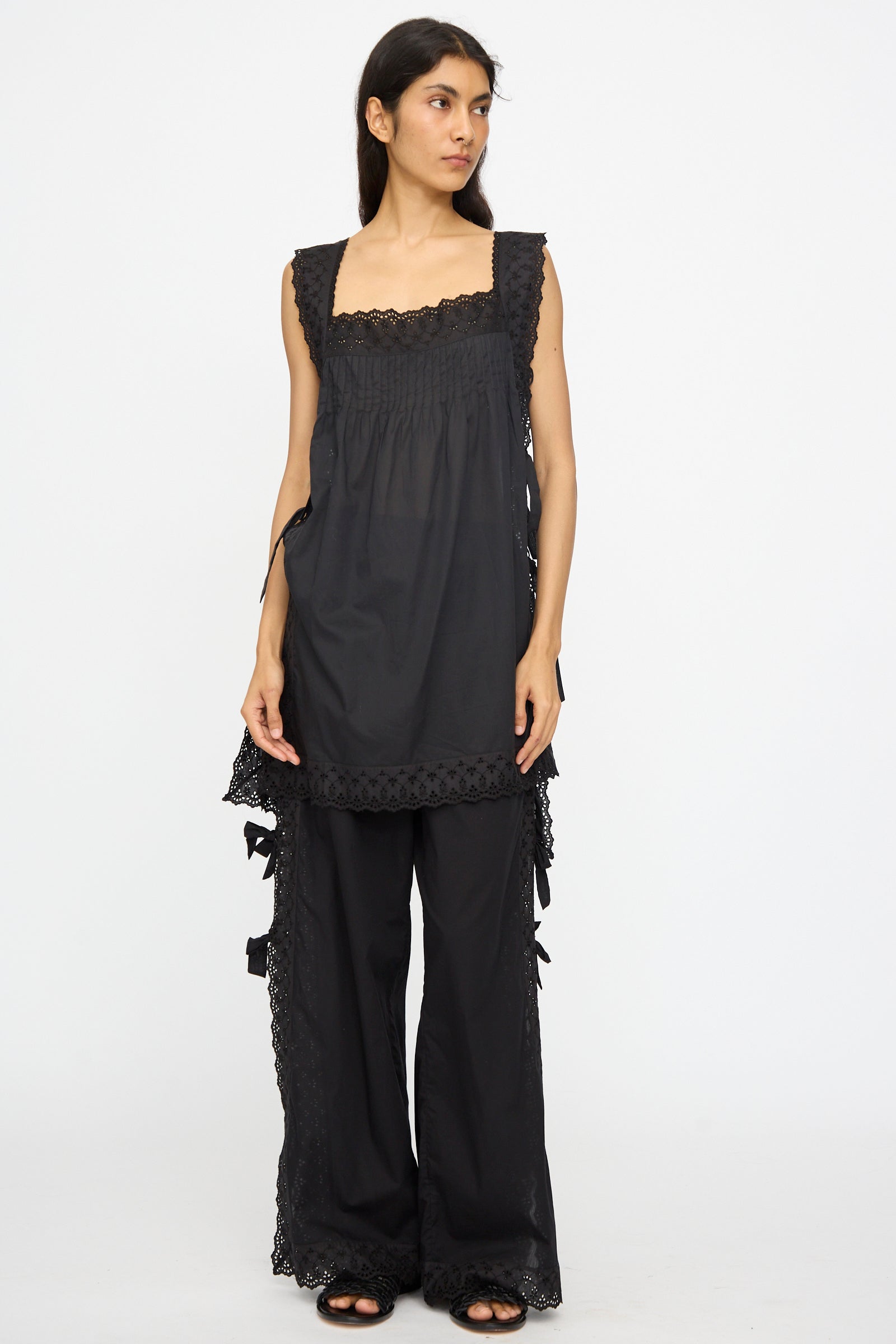 A woman wears the Loretta Caponi Oriana Top in Nero, featuring black lace details, paired with matching wide-leg pants. Made in Italy, shown against a plain white background.
