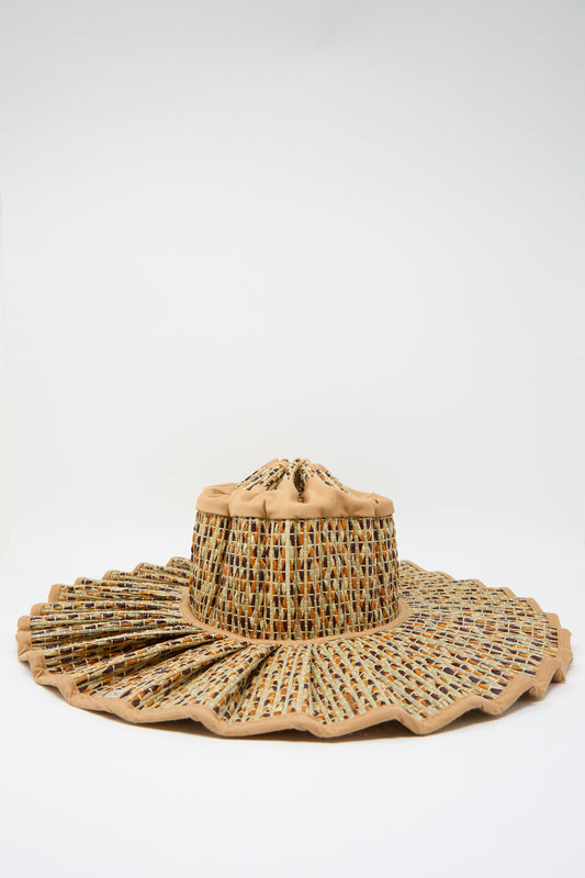The Lorna Murray Island Capri Maxi Hat in Dawn features a wide brim and multicolored textured weave from natural grass fibers, accented with beige fabric, shown against a plain white background.