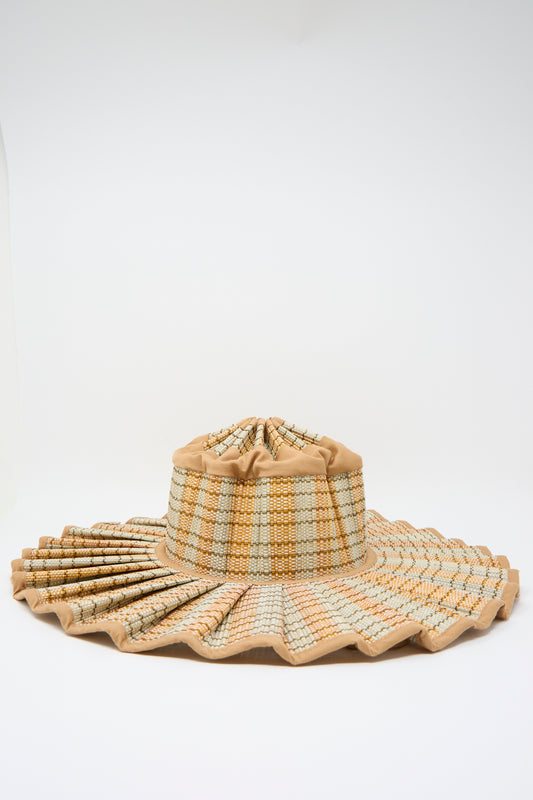 The Lorna Murray Island Capri Maxi Hat in Petra features natural grass fibers, a wide pleated brim, gathered crown, beige and light brown checks, and offers stylish UPF 50+ sun protection.