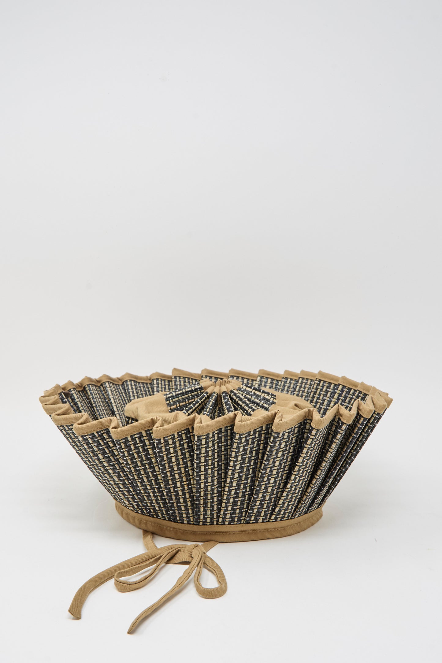 The Island Capri Maxi Hat in Nara by Lorna Murray is a woven, flared sun hat crafted from natural grass fibers, with a zigzag rim and tan ties, shown on a plain white background.