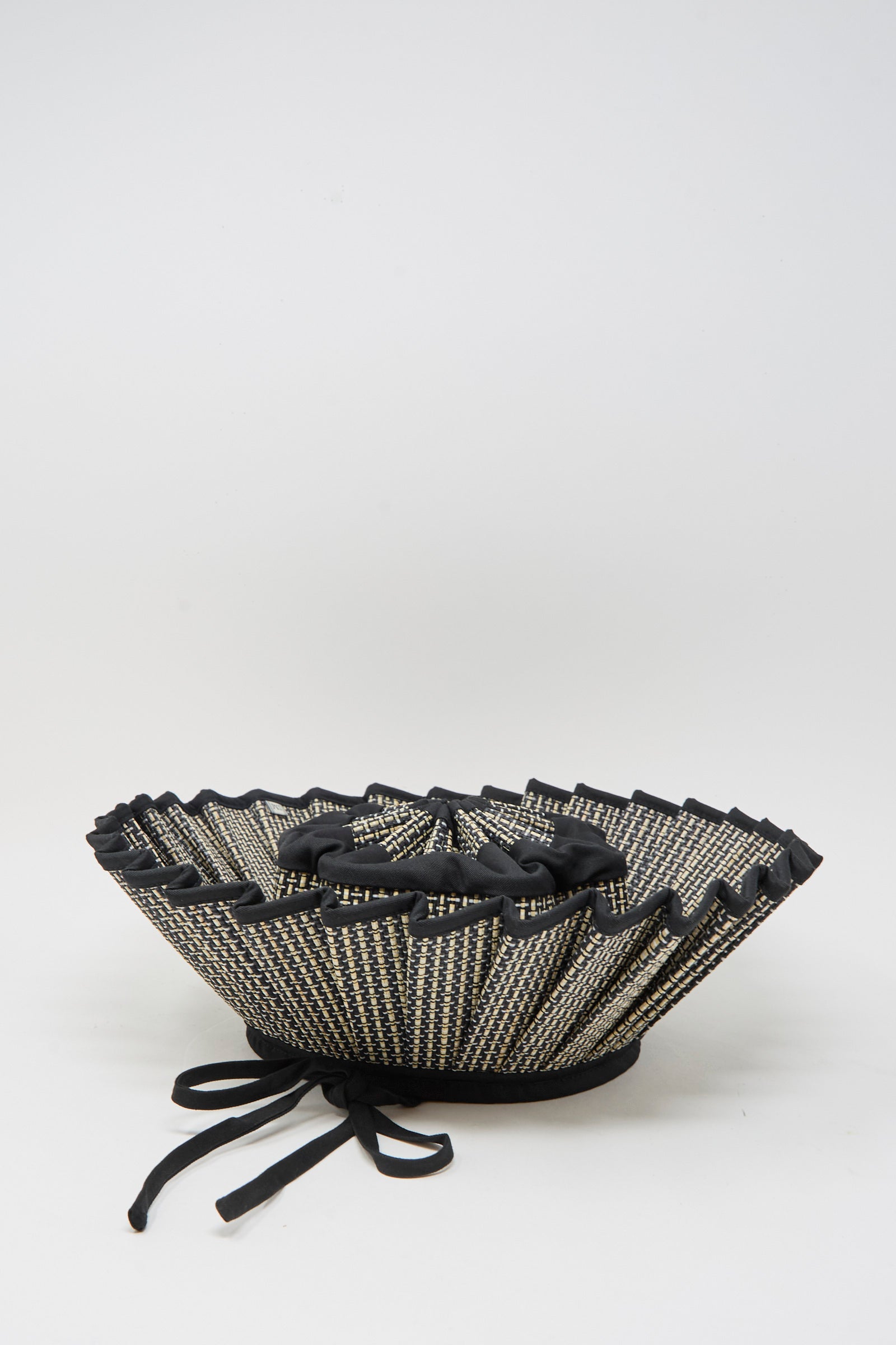 The Island Capri Maxi Hat in Melbourne by Lorna Murray is a black and white pleated sun hat with laces and ties, made from natural grass fibers and shown on a plain white background.