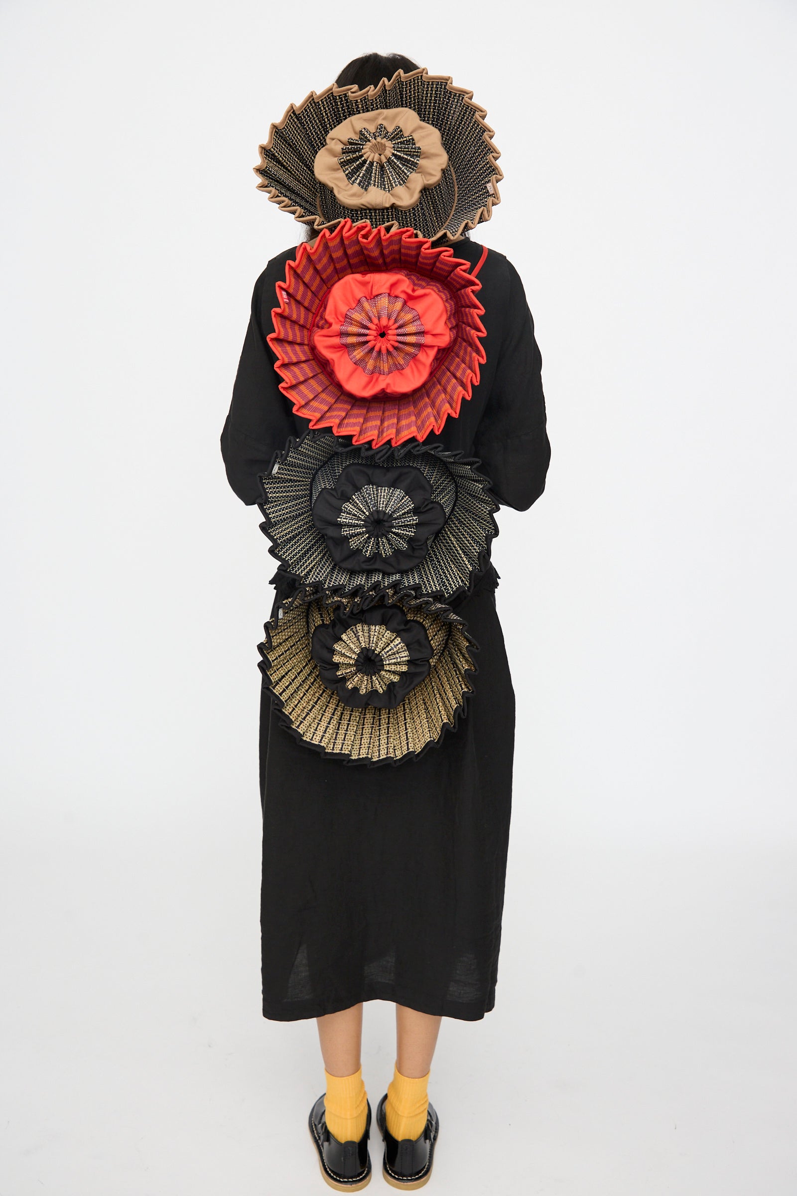 Person wearing a black dress with Lorna Murray hats ties on her bac on a white background