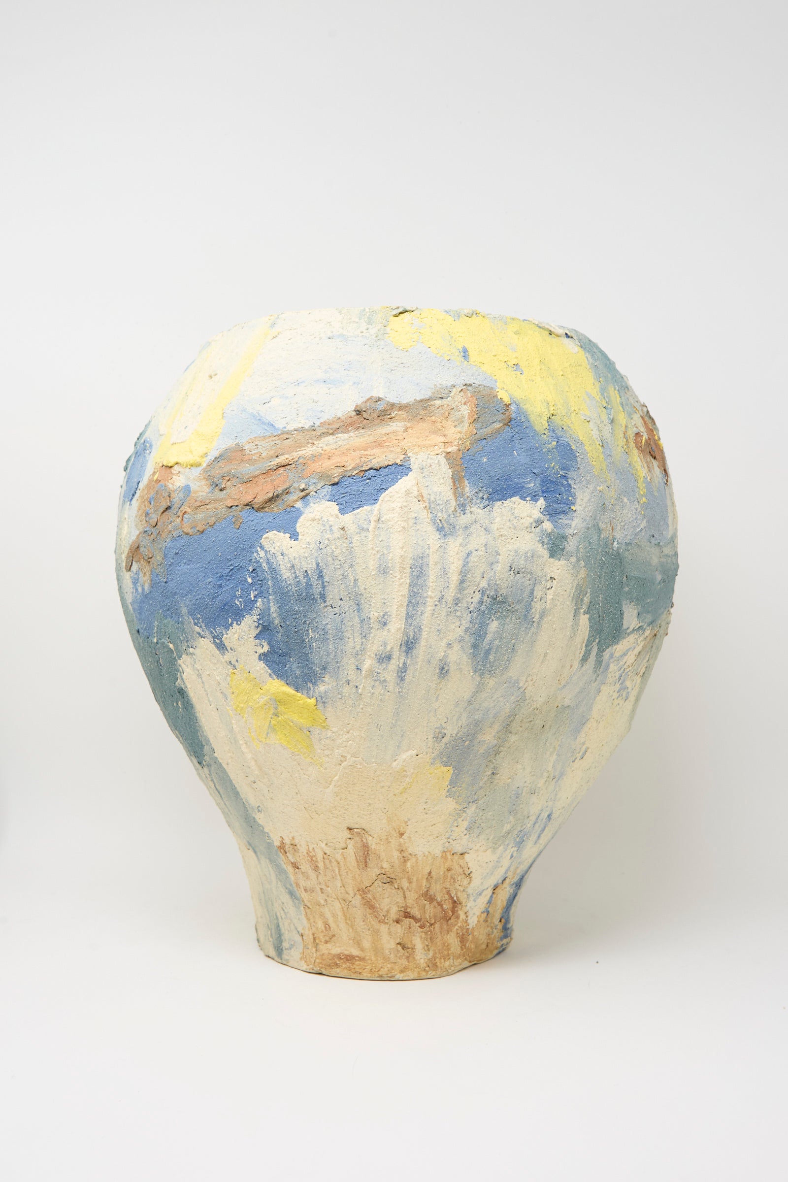The Hand Built Cloudy Day Vessel by Lost Quarry is a large, round sculptural clay vase with a textured surface, handmade and painted in abstract blue, yellow, white, and brown brushstrokes on a plain white background.