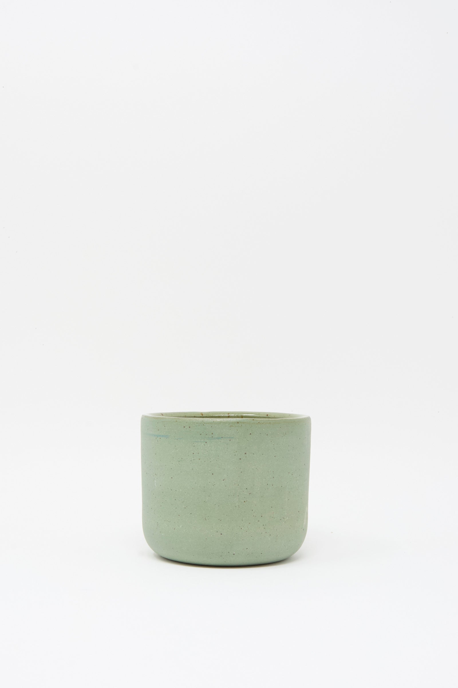 The Hand Built Knot Mug in Sage I by Lost Quarry, a small light green handmade ceramic mug with an oversized handle, is centered against a plain white background.