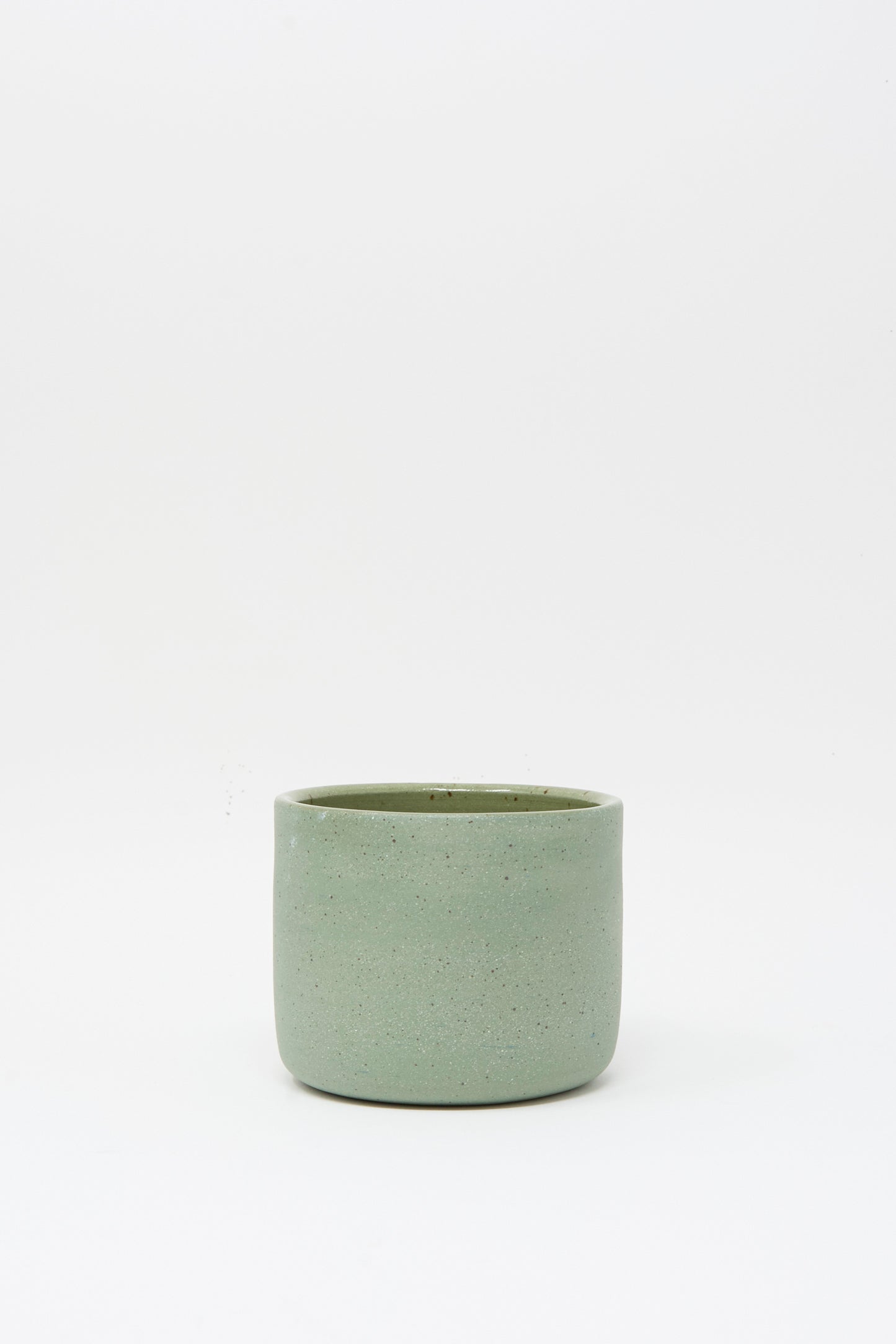 The Lost Quarry Hand Built Knot Mug in Sage II, a simple cylindrical ceramic mug with a sage glaze, is displayed on a plain white background.