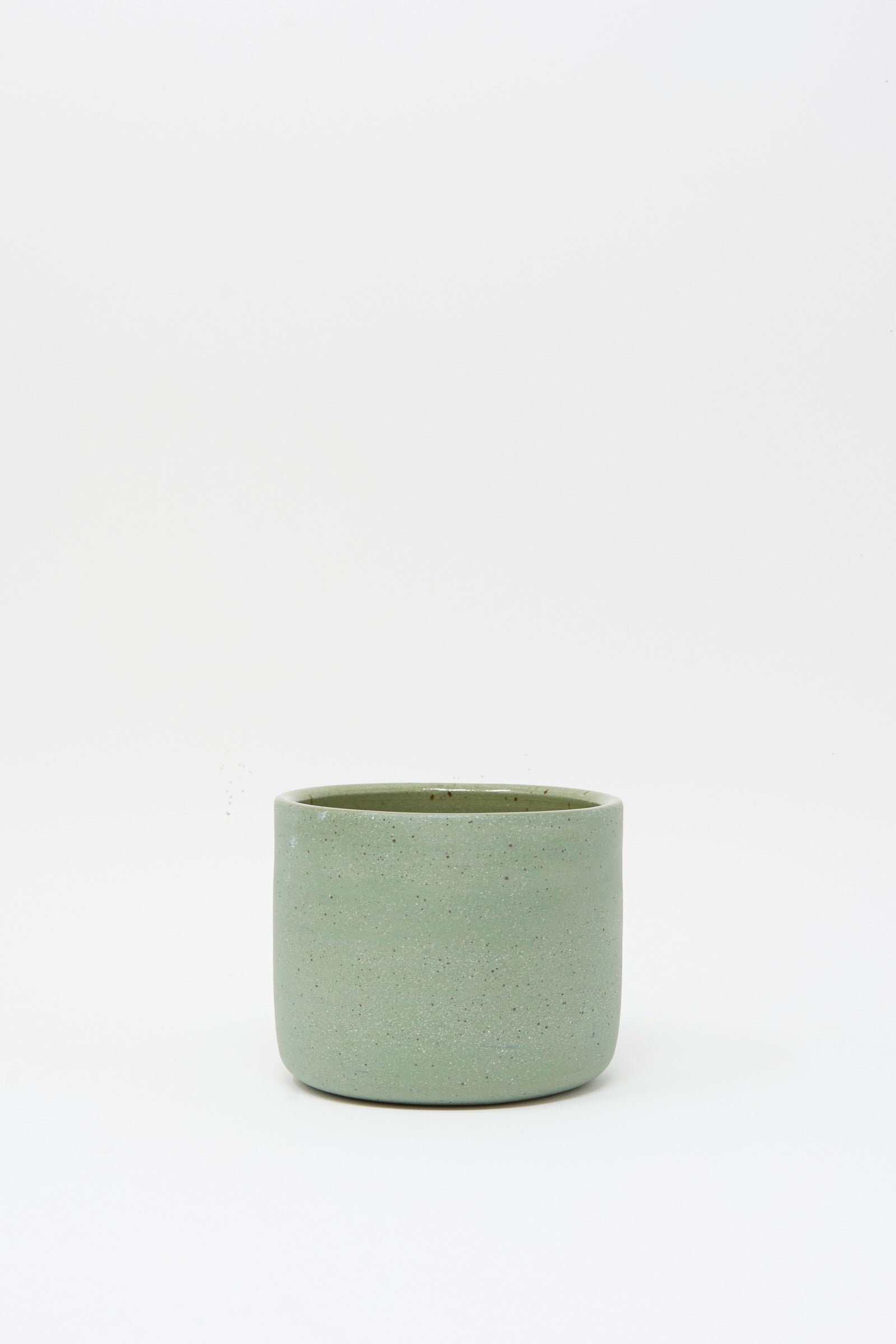 The Lost Quarry Hand Built Knot Mug in Sage II, a simple cylindrical ceramic mug with a sage glaze, is displayed on a plain white background.