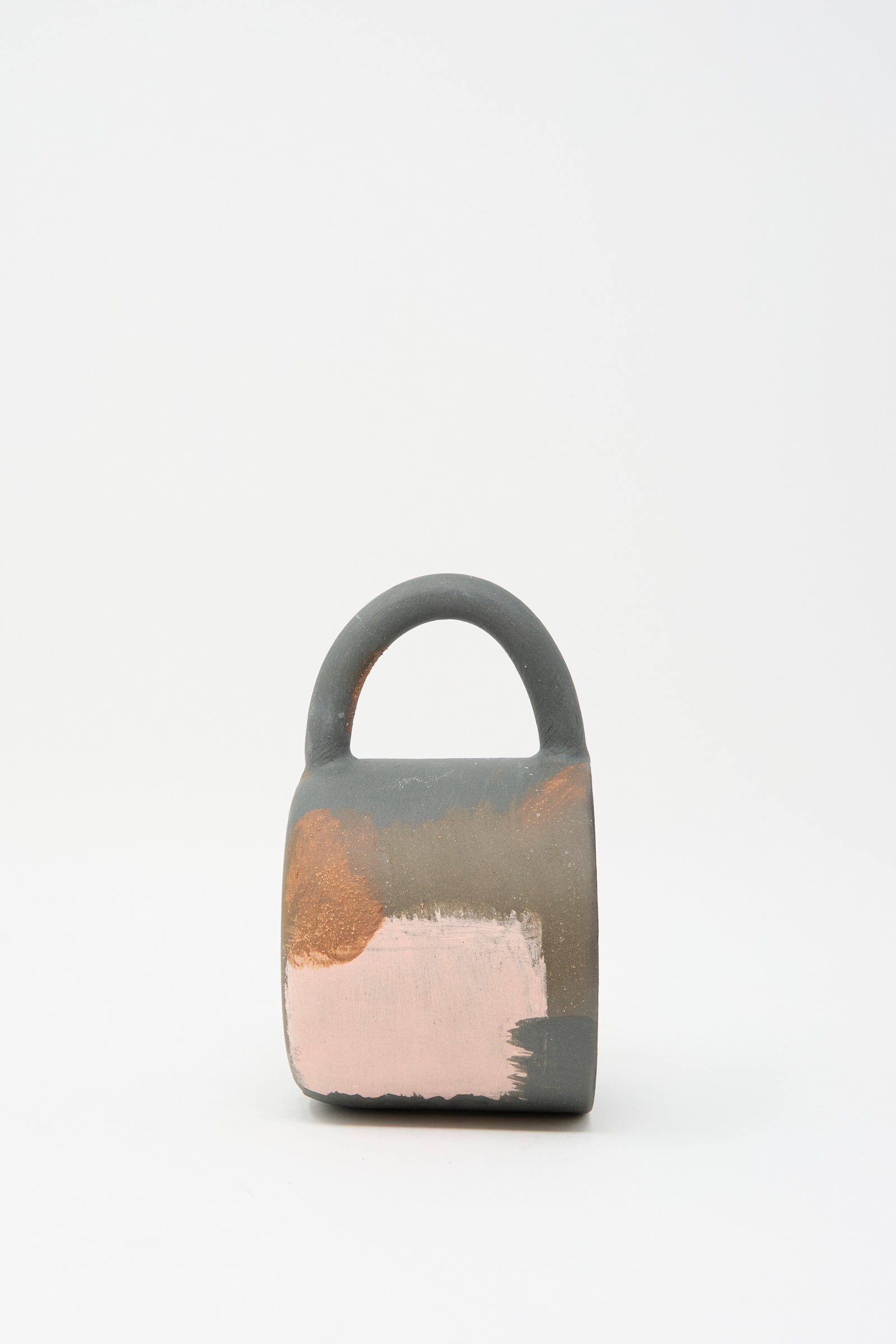 A Lost Quarry "Hand Built Mugs in Brown Multi" features a lock-shaped design with an oversized handle, showcasing a mixed palette of gray, copper, and pink against a plain white background.