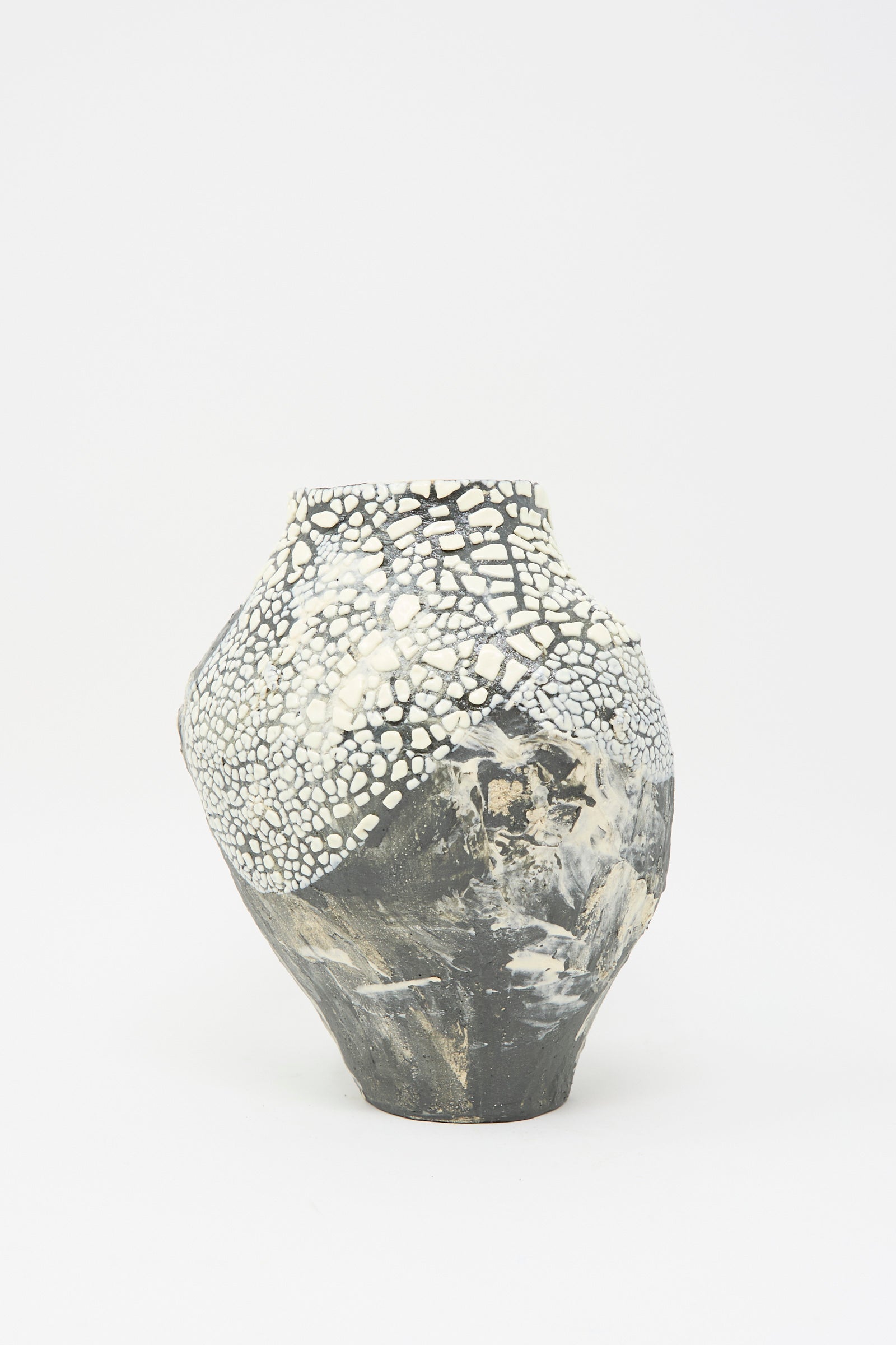 The Lost Quarry Hand Built Textured Vessel in Black and White showcases a dramatic cracked black and white design, accentuated by its textured glaze on a plain white background.