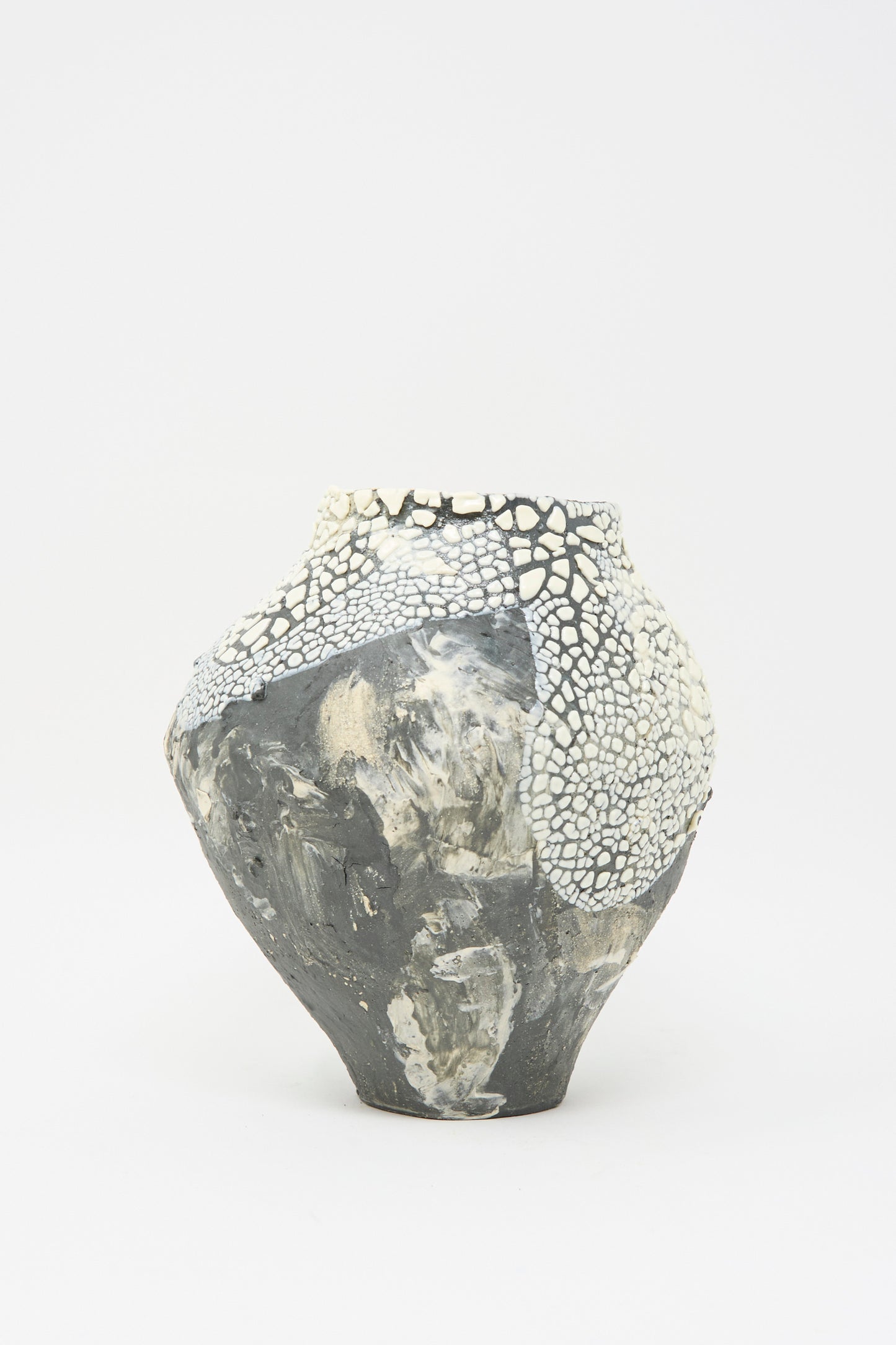 The Hand Built Textured Vessel in Black and White by Lost Quarry is a sculptural ceramic piece with a wide, rounded body, featuring mixed gray and white patterns on its plain background.