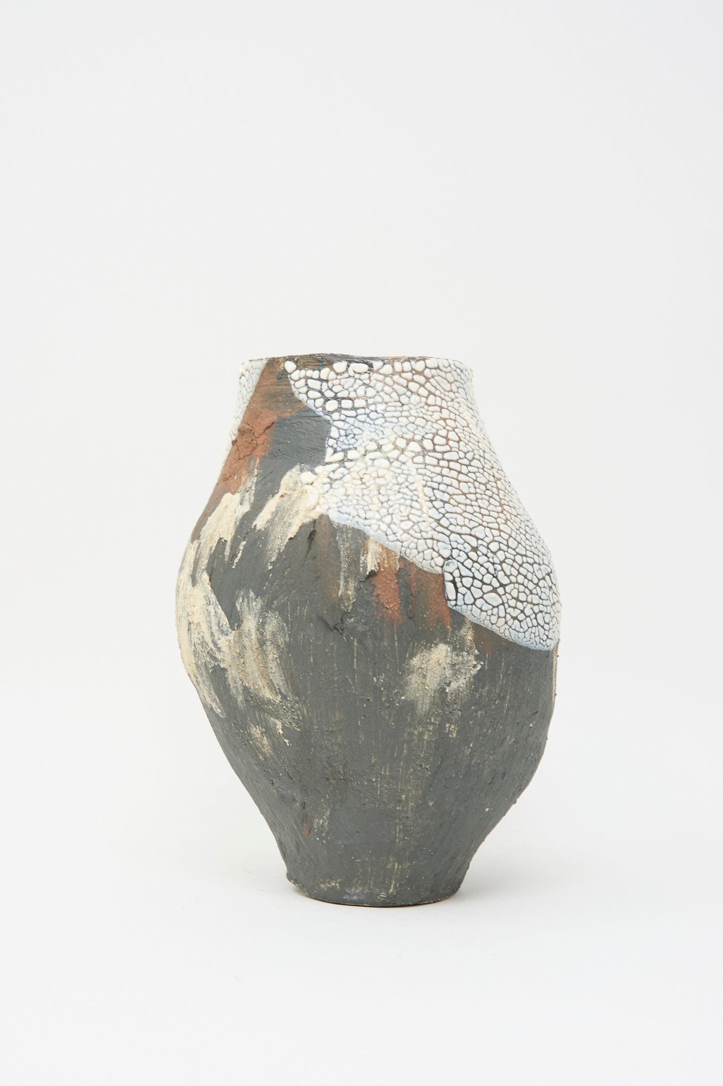 The "Hand Built Textured Vessel in Black Multi" by Lost Quarry features a multicolored ceramic design with gray, white, and brown cracked patterns against a plain white backdrop, enhanced by a unique textured glaze.