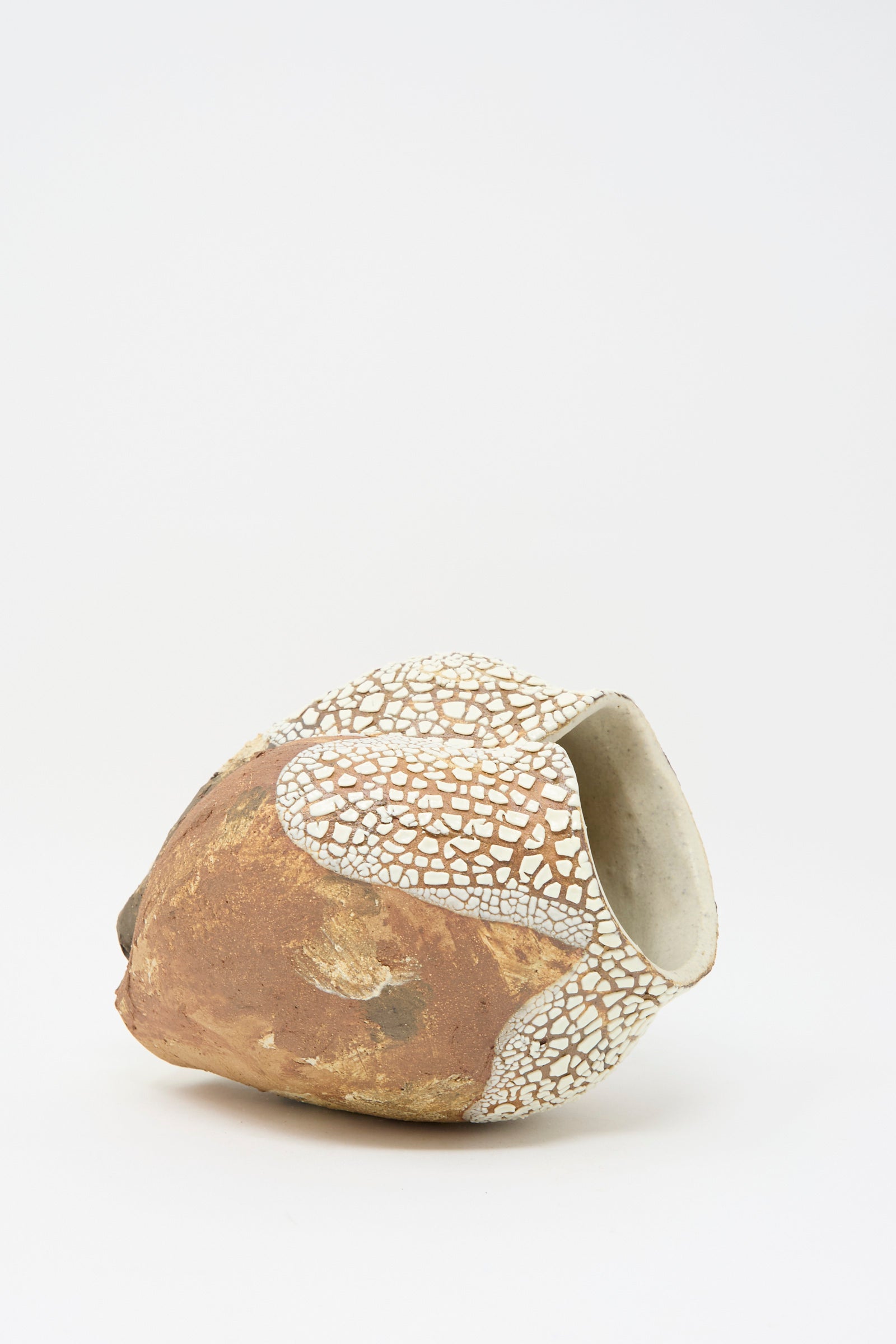 The Lost Quarry's Hand Built Textured Vessel in Terracotta Mix features a brown and white ceramic design with an irregular glaze and asymmetrical opening, set against a plain white background.