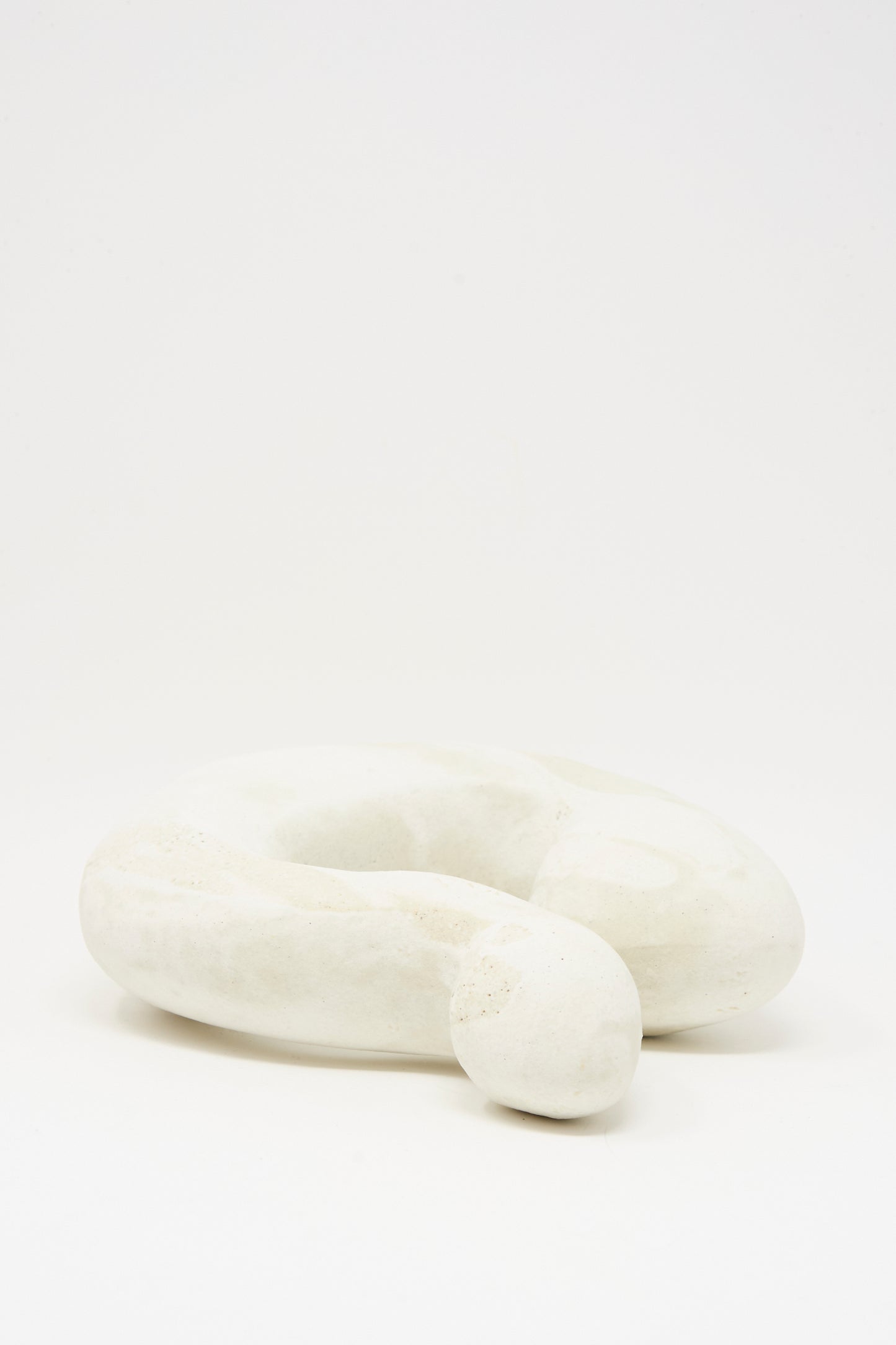Hand Built Vessel No. 000980 by Lost Quarry is a smooth, white abstract ceramic piece with a coiled, looped form displayed on a plain white background.