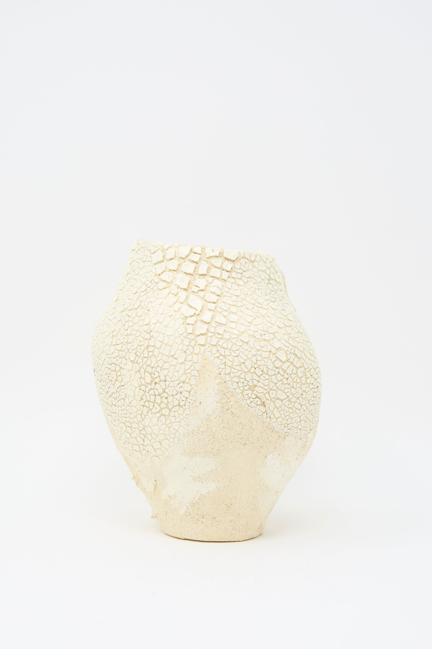 The Lost Quarry "Hand Built Textured Vessel in Neutral and White" is a sculptural ceramic clay piece that features a wide body, narrow opening, and uneven surface with crackle and square patterns enhanced by a textured glaze.