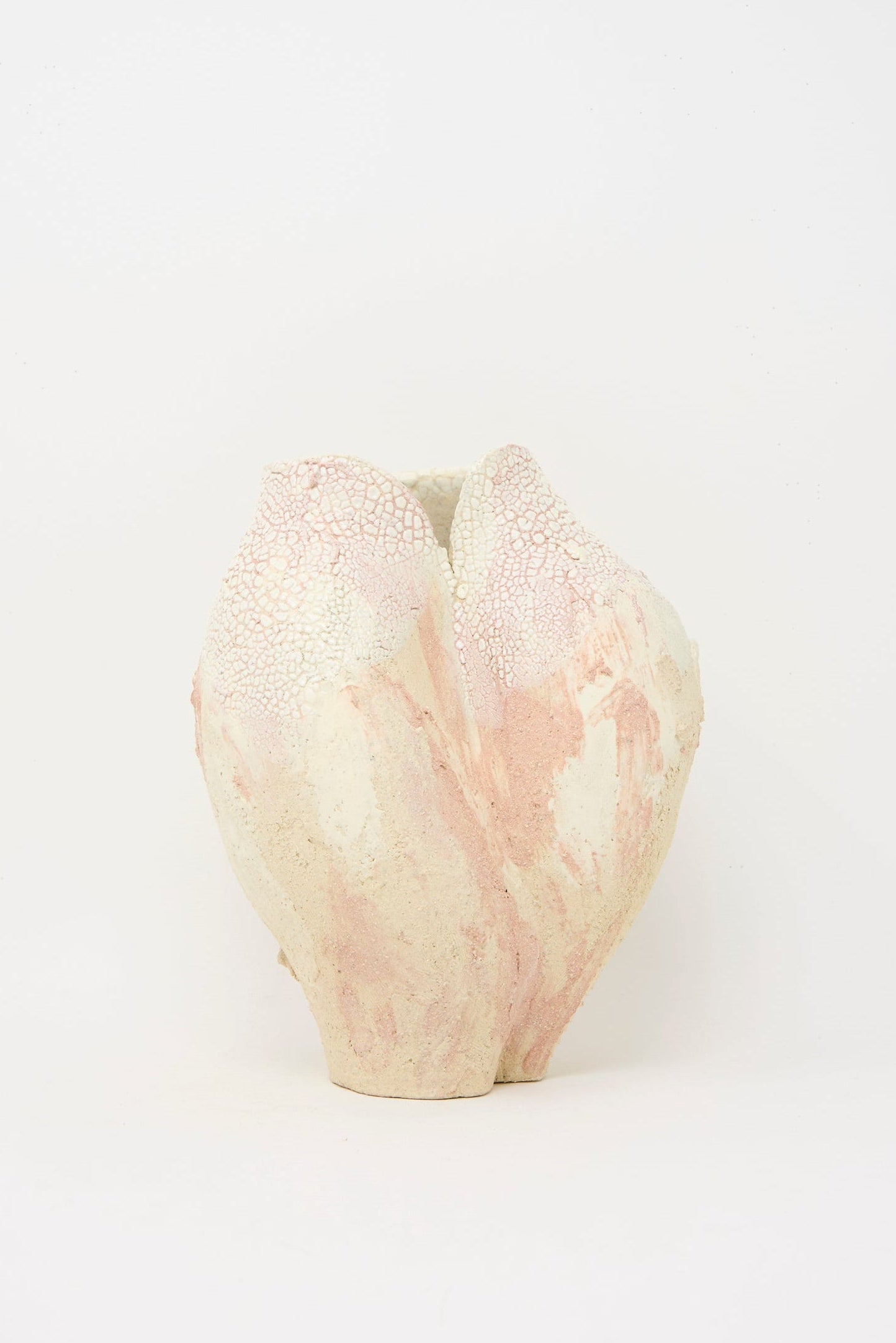 The Lost Quarry Medium Hand Built Textured Vessel in Pale Pink features a ceramic construction with a textured surface, pale pink and white tones, and an organic, asymmetrical shape set against a plain white background.