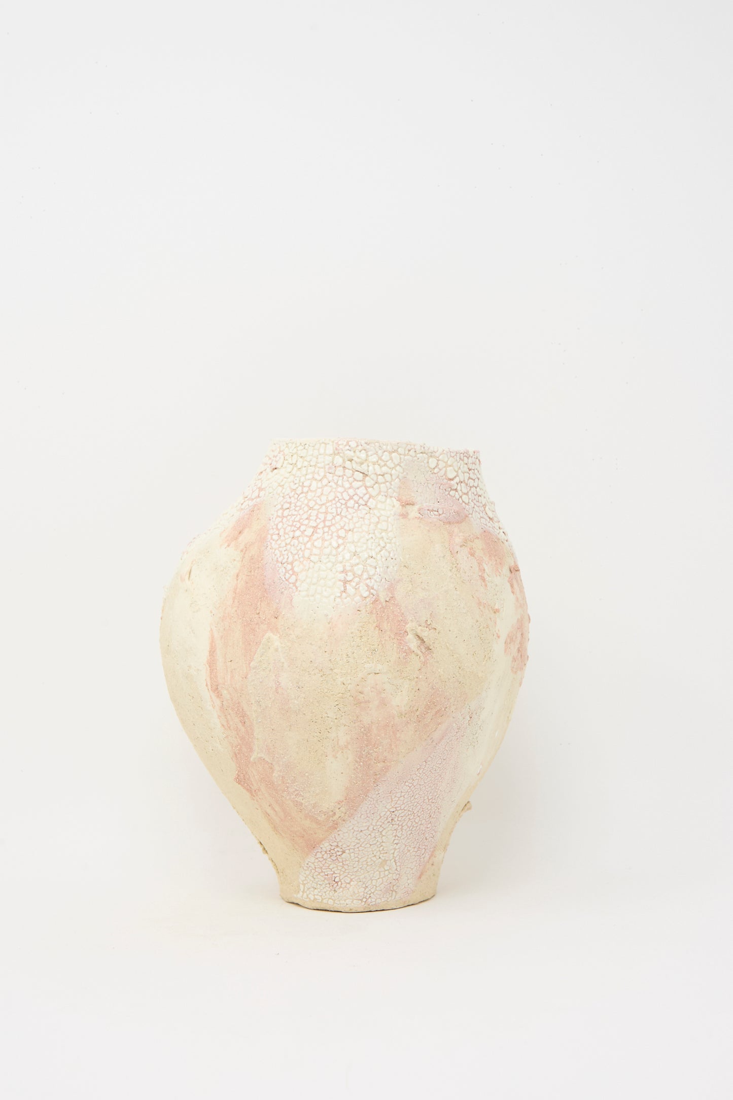 The Lost Quarry Medium Hand Built Textured Vessel in Pale Pink features a round ceramic form with a textured off-white and pale pink surface, showcased against a plain white background.