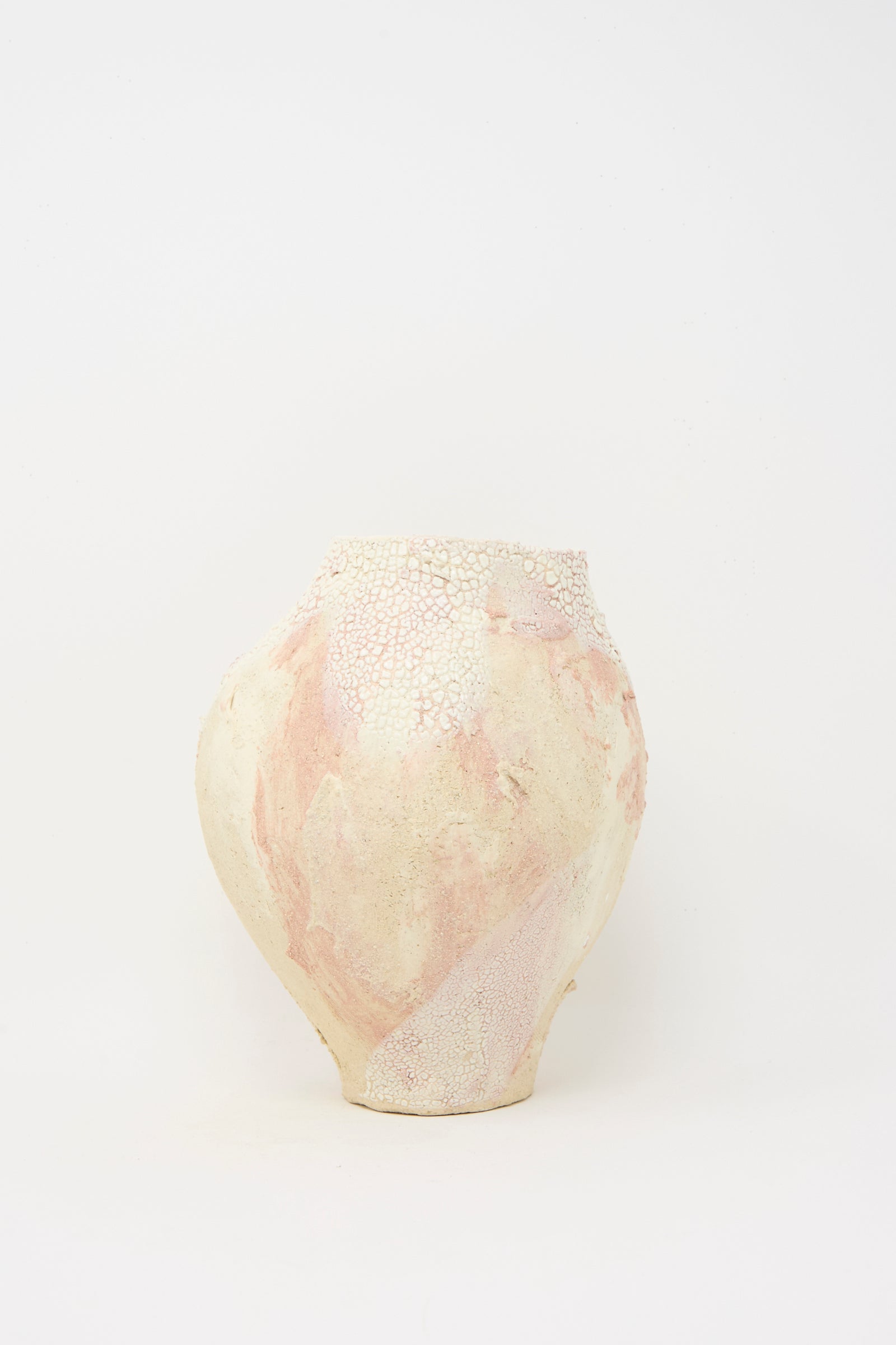 The Lost Quarry Medium Hand Built Textured Vessel in Pale Pink features a round ceramic form with a textured off-white and pale pink surface, showcased against a plain white background.
