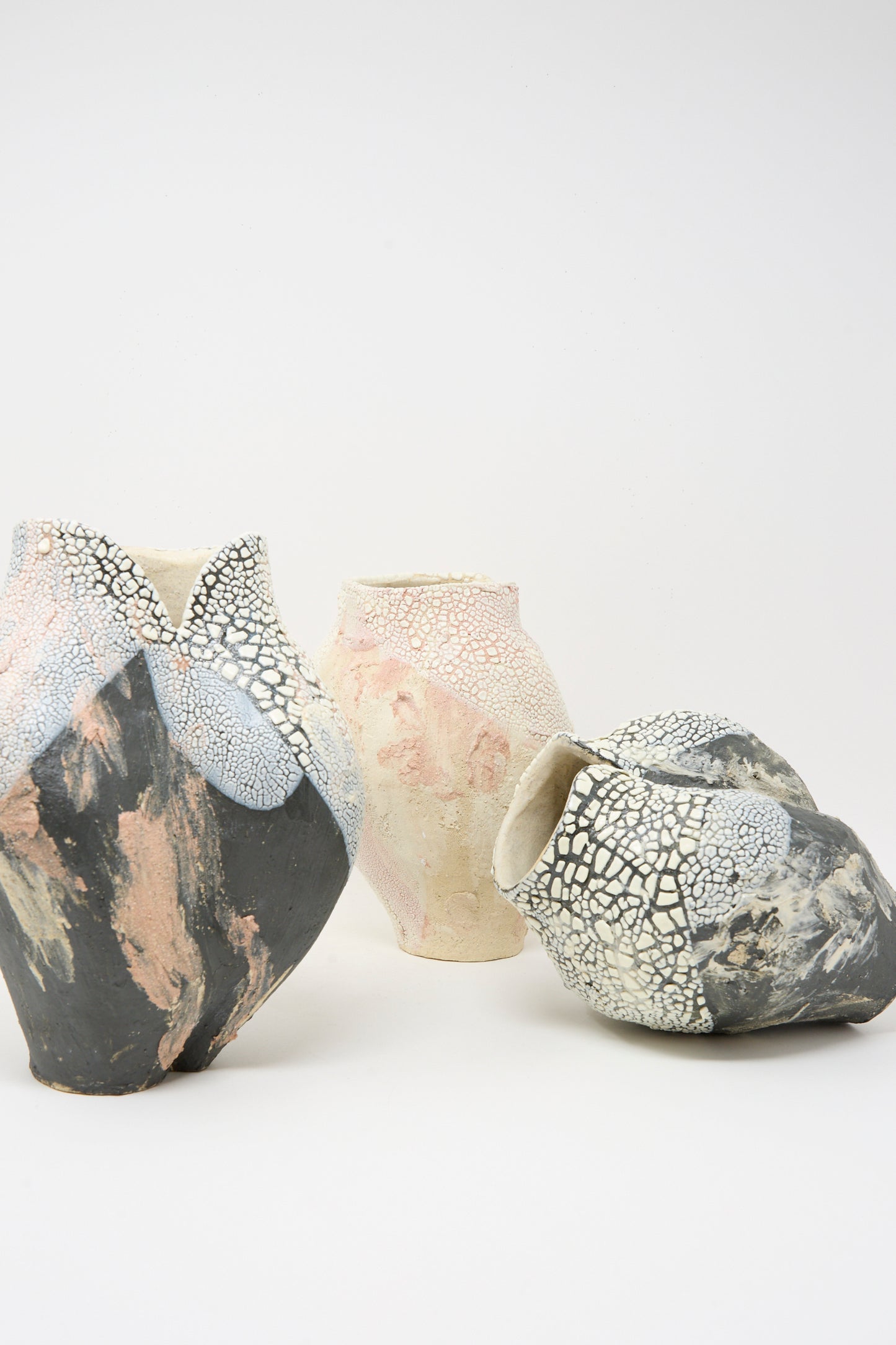The Lost Quarry Medium Hand Built Textured Vessel in Pale Pink features a unique, irregular shape and a crackled surface, displayed against a plain white background.