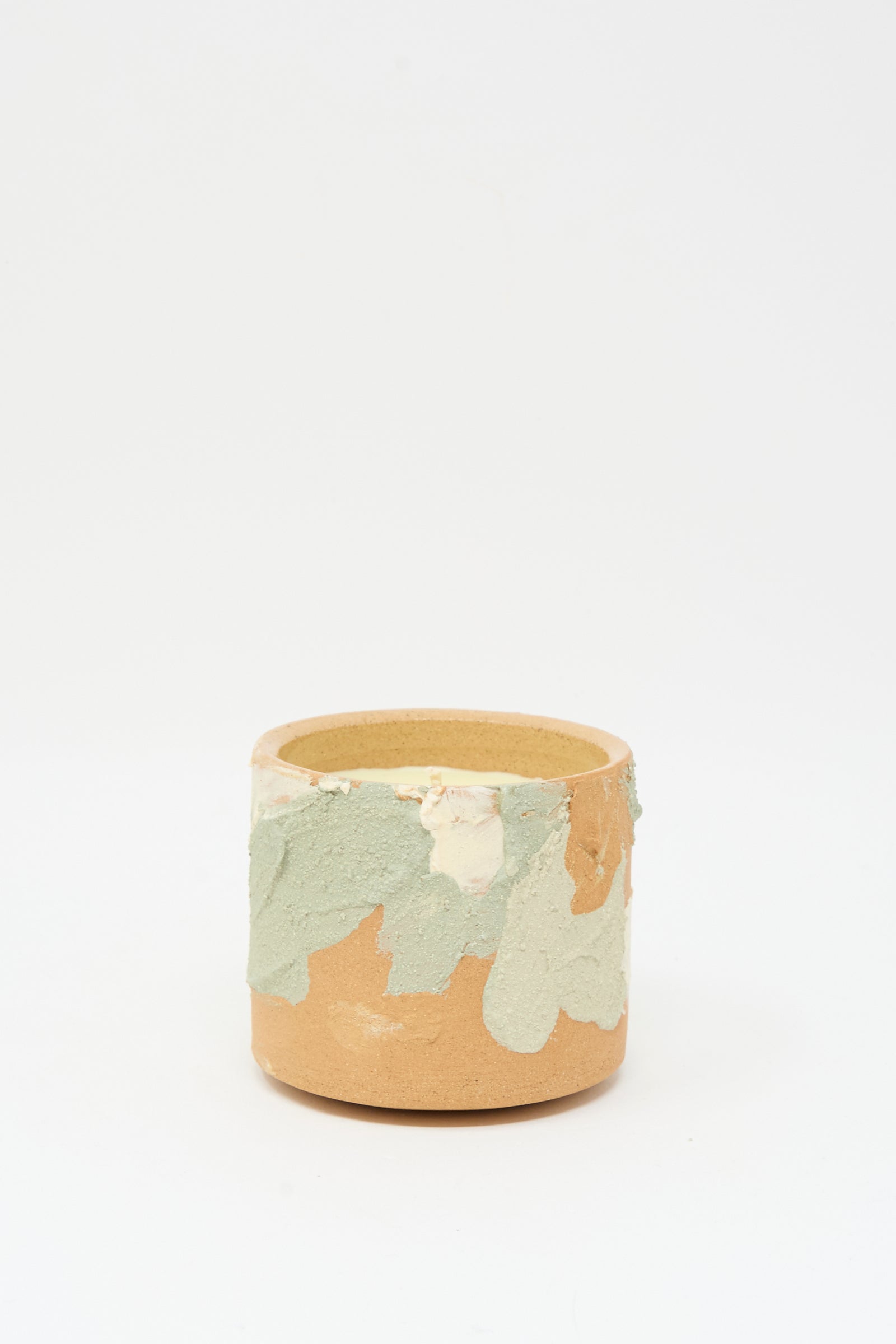 The Neroli Candle in Dusty Mint Adobe Multi by Lost Quarry is a small, hand-built cylindrical ceramic vessel with a textured light green and off-white glaze near the rim, shown against a plain white background.