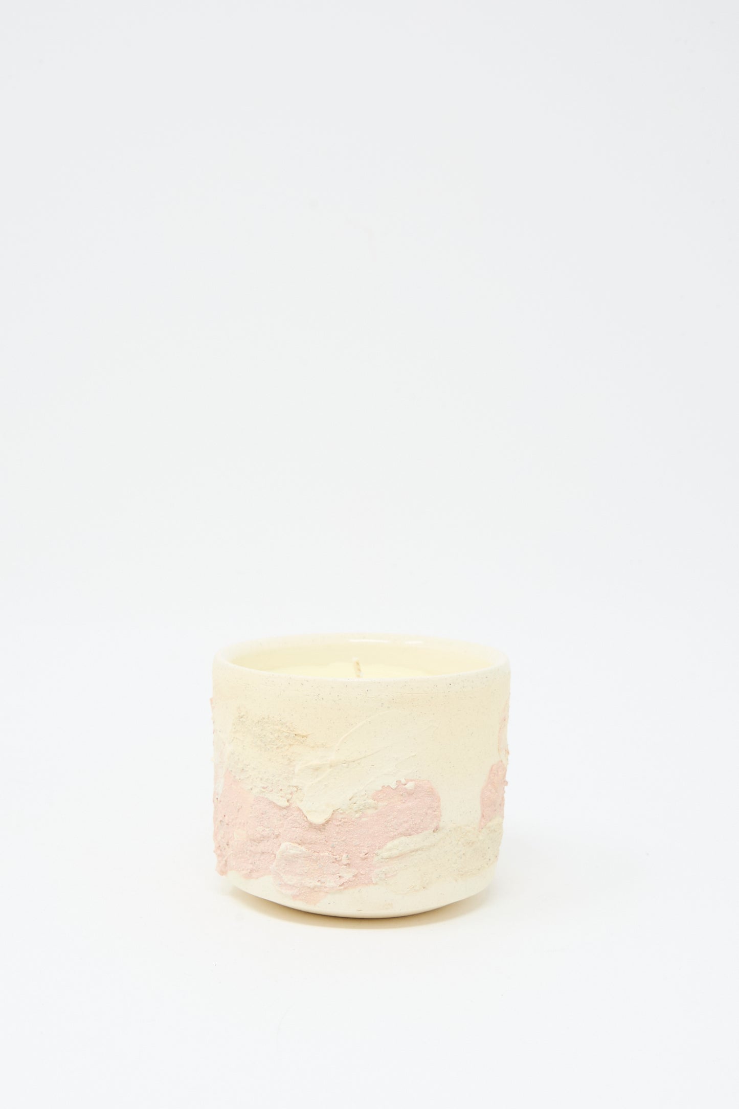 The Neroli Candle in Pink Multi by Lost Quarry is a small round hand-built ceramic vessel with a textured cream and pink surface, displayed on a white background.