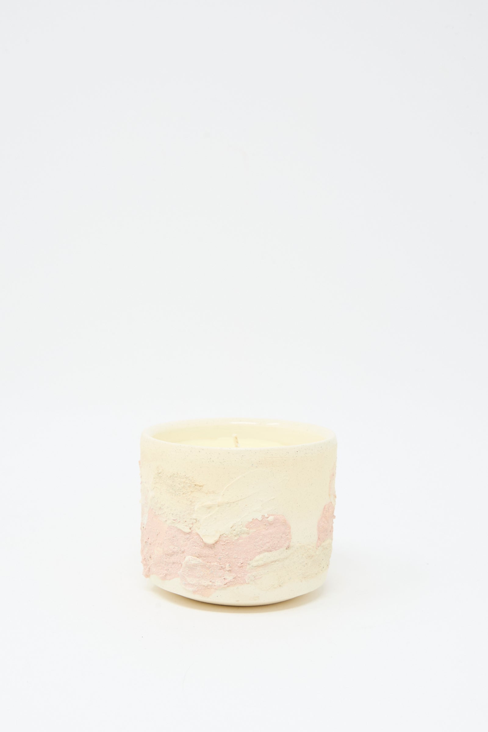 The Neroli Candle in Pink Multi by Lost Quarry is a small round hand-built ceramic vessel with a textured cream and pink surface, displayed on a white background.