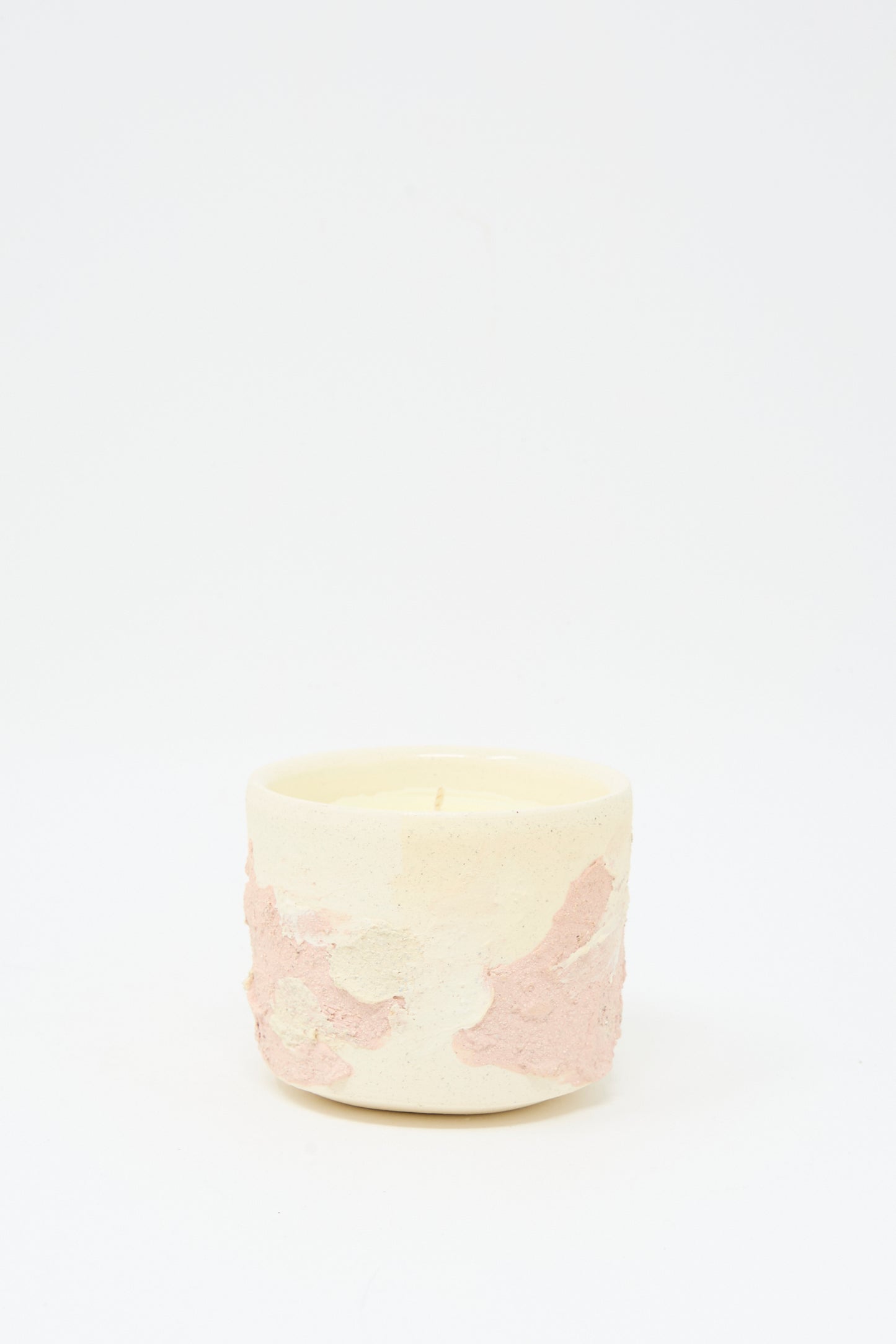 The Lost Quarry Neroli Candle in Pink Multi is a small, cream-colored scented candle in a hand-built ceramic vessel with light pink accents, displayed against a plain white background.