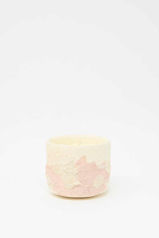 The Neroli Candle in Pink Multi by Lost Quarry is a small, round scented candle set in a hand-built ceramic vessel with pale pink and cream hues, displayed against a plain white background.