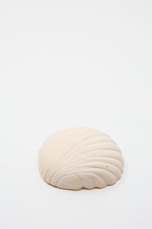 The Small Ceramic Shell Dish in Light Pink by Lost Quarry is displayed against a simple white backdrop, highlighting its craftsmanship and texture reminiscent of a natural seashell.