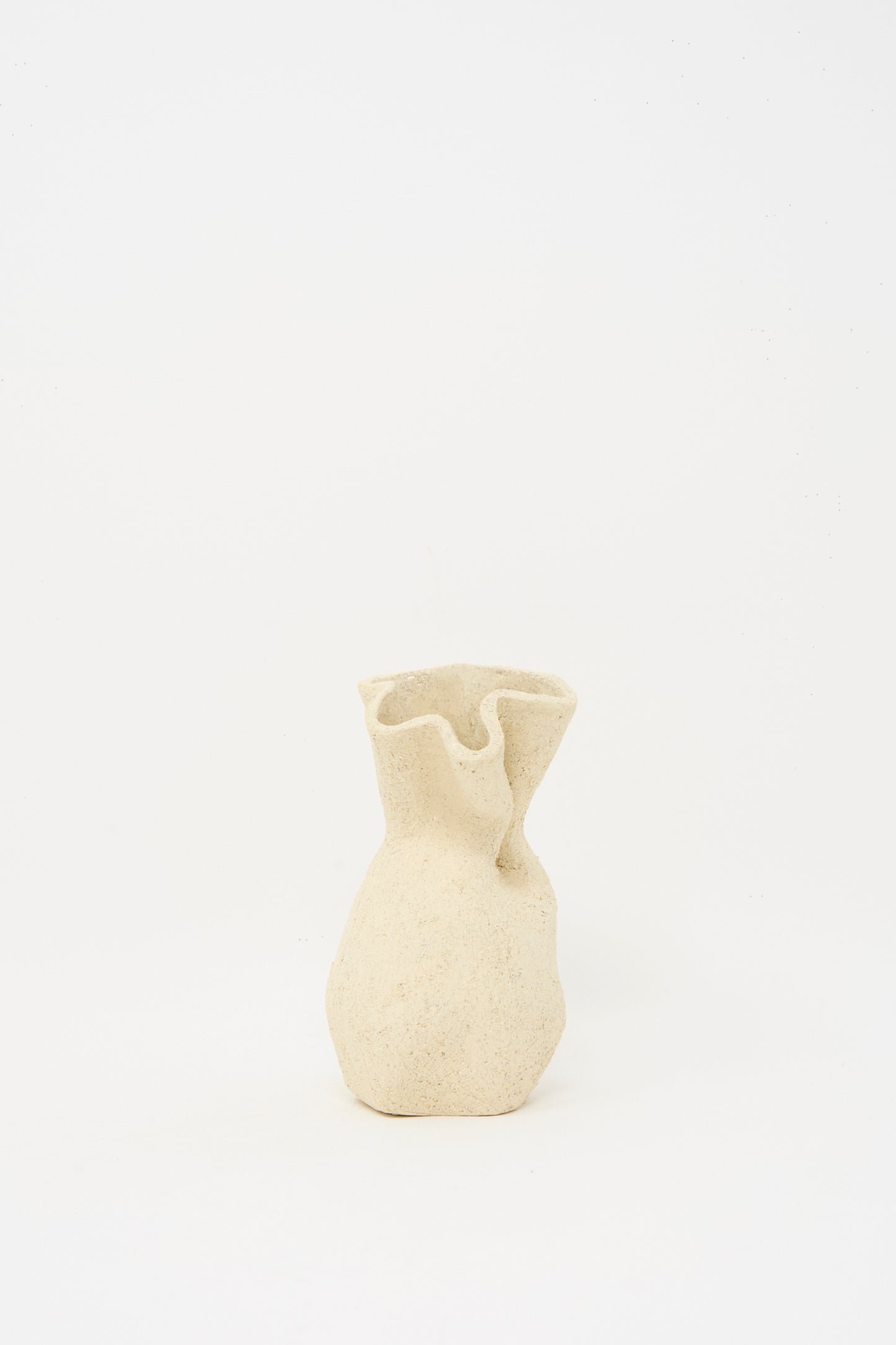 The Textured Clay Folded Vessel I by Lost Quarry is a small, beige ceramic vase with a wavy rim and tactile surface, crafted from white sculpture clay.