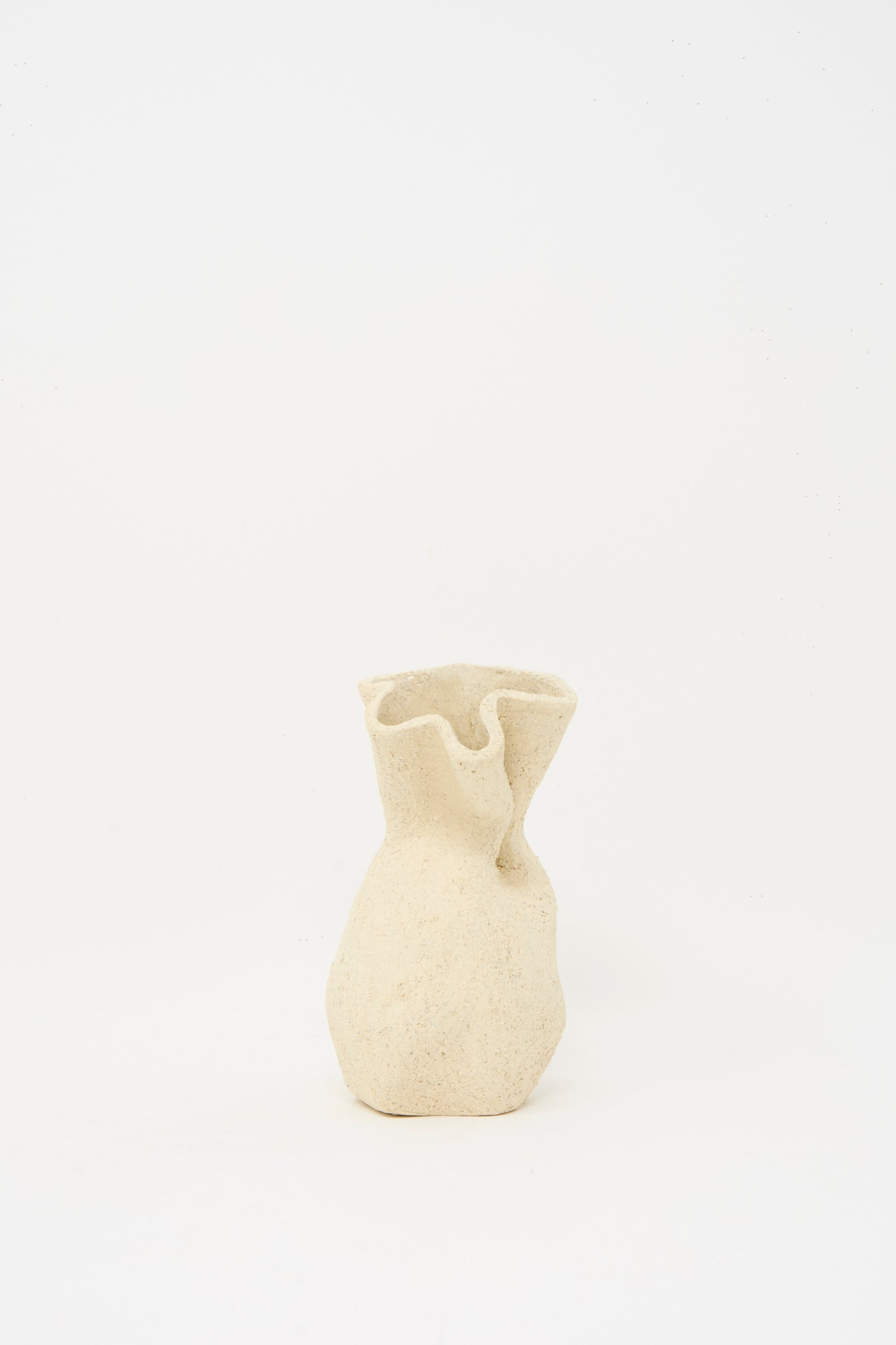 The Textured Clay Folded Vessel I by Lost Quarry is a small, beige ceramic vase with a wavy rim and tactile surface, crafted from white sculpture clay.