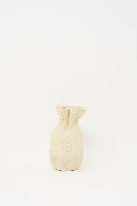 The Textured Clay Folded Vessel III by Lost Quarry is a small, handmade beige ceramic vase with an irregular shape and textured surface, ideal for unique floral arrangements, shown against a plain white background.