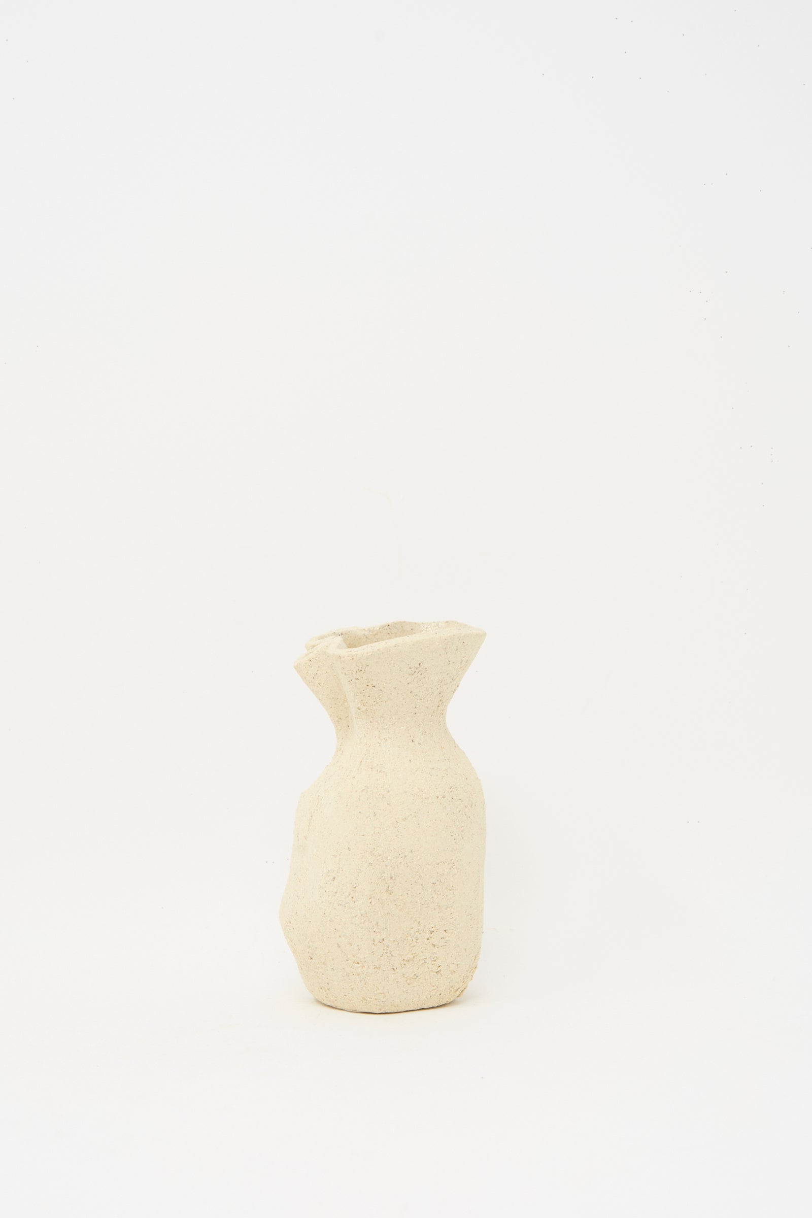 The Lost Quarry Textured Clay Folded Vessel III is a small, beige, handmade piece with a textured finish, uneven rim, and irregular shape—ideal for floral arrangements—shown against a plain white background.