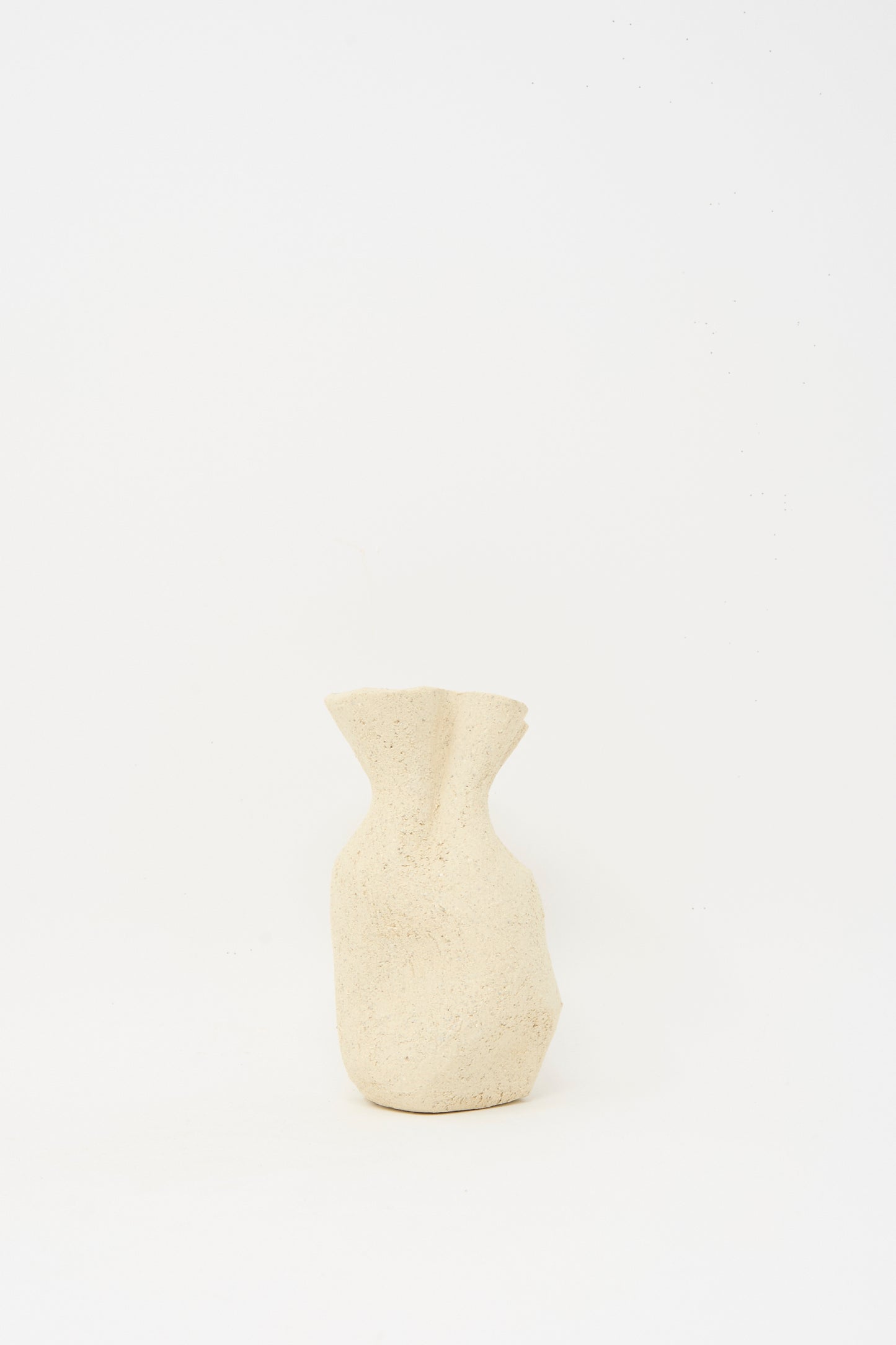 The Textured Clay Folded Vessel III by Lost Quarry is a beige, irregularly shaped ceramic vase with a rough texture, ideal for floral arrangements, crafted from white sculpture clay and shown against a plain white background.