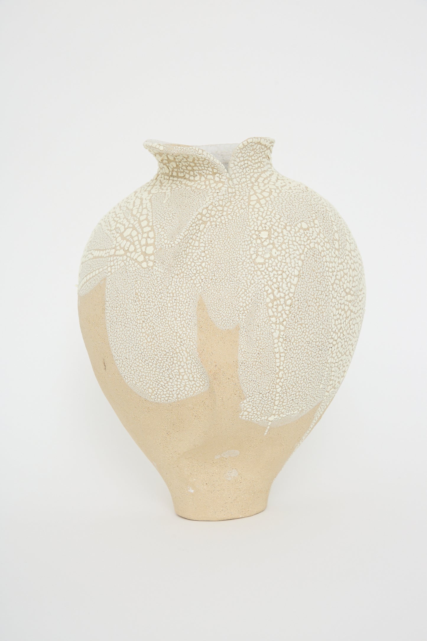 The Vessel No. 741 in White Sculpture Clay by Lost Quarry is a hand-built beige ceramic vase with a wide body and narrow neck, featuring a textured white pattern reminiscent of cracked paint on its upper portion. The background is plain white.