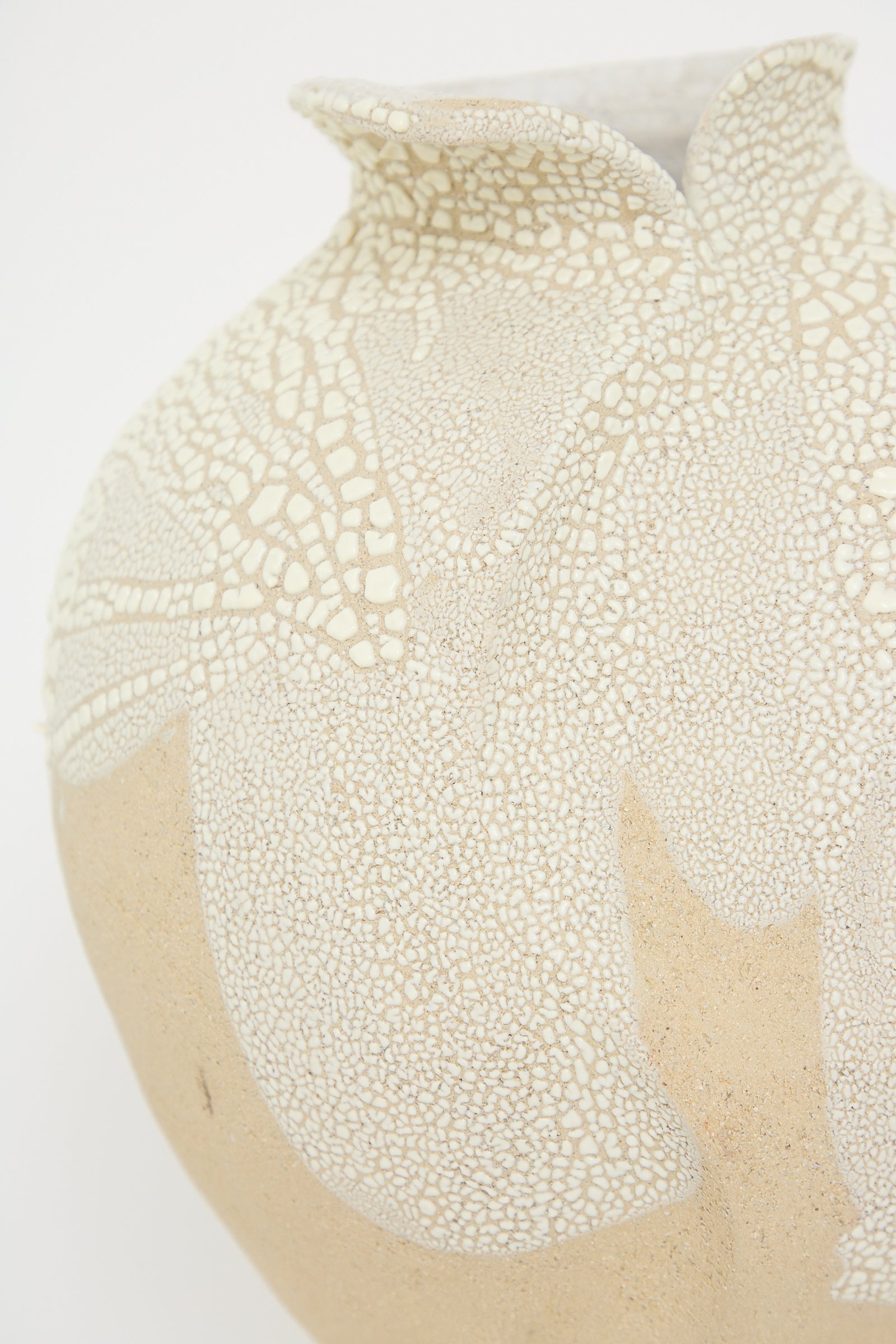 A close-up of Vessel No. 741 in White Sculpture Clay by Lost Quarry, hand-built from beige ceramic and featuring a textured, crackled white glaze pattern near the top.