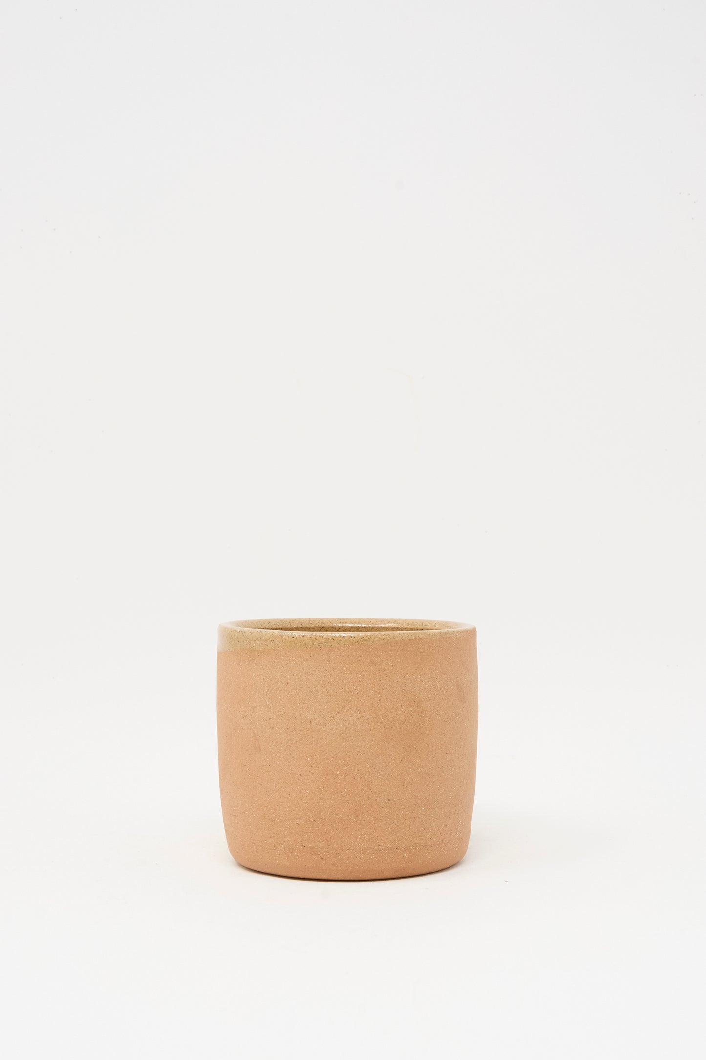 The Overhand Knot Mug in Adobe by Lost Quarry, a small plain cylindrical terracotta mug, sits centered on a white background.