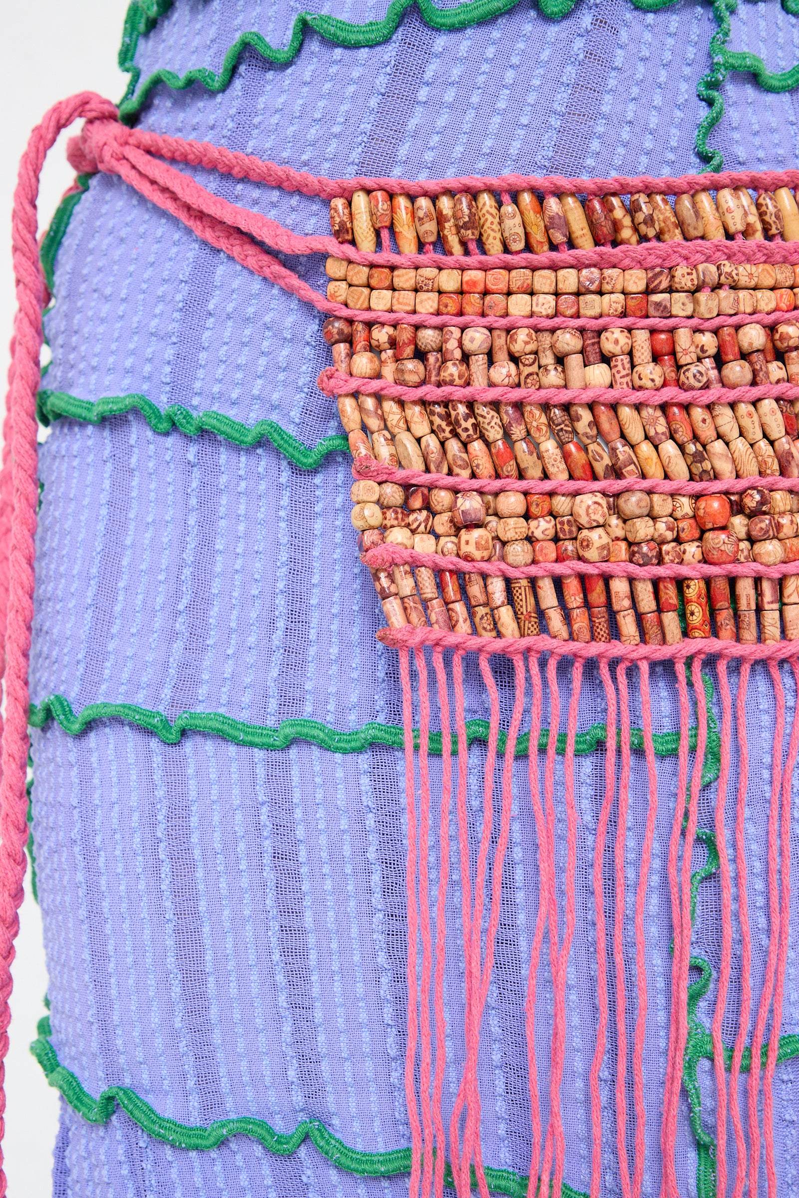 A Luna Del Pinal belt with wooden beads and tassels on it.