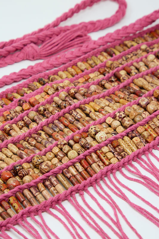 Colorful Luna Del Pinal beaded necklace with pink tassels on a white background, featuring wooden beads.