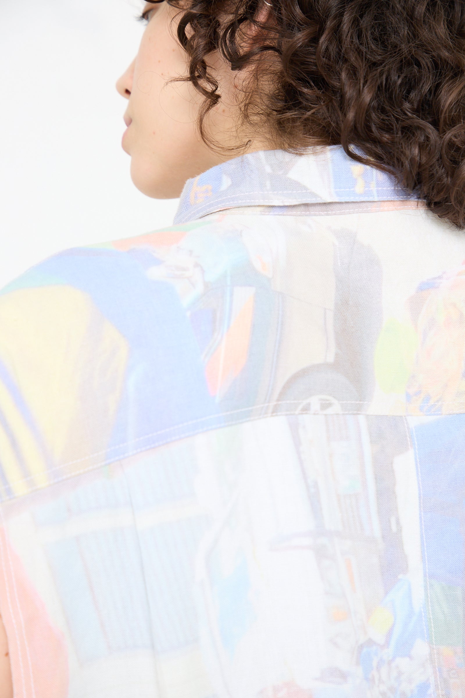 The back view of a woman wearing Luna Del Pinal's Hemp Sleeveless Shirt in Oversized Digital Market Print.