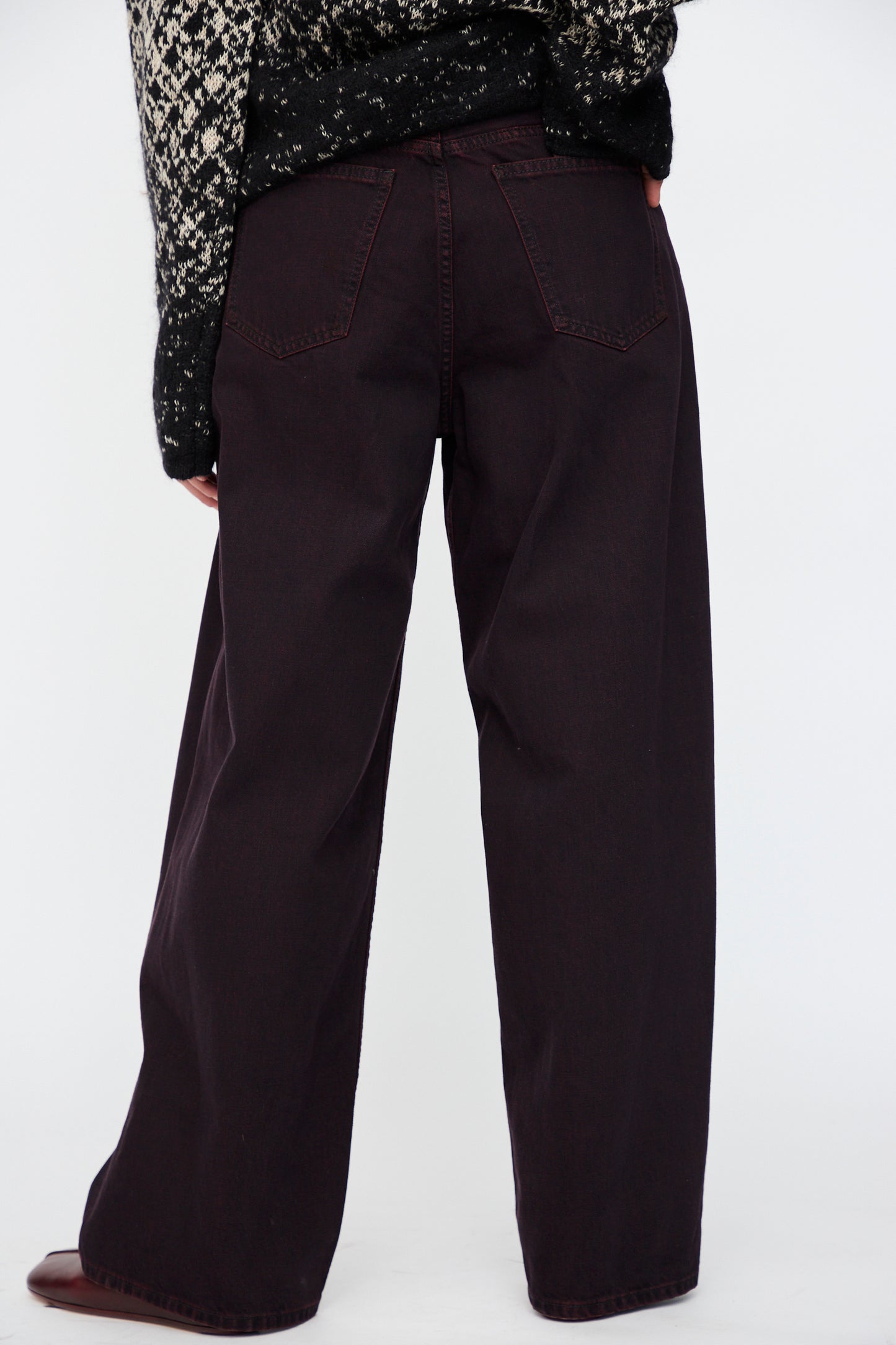 A person wearing MM6 5 Pocket Pants in Burgundy, standing against a plain white background, shown from the back.