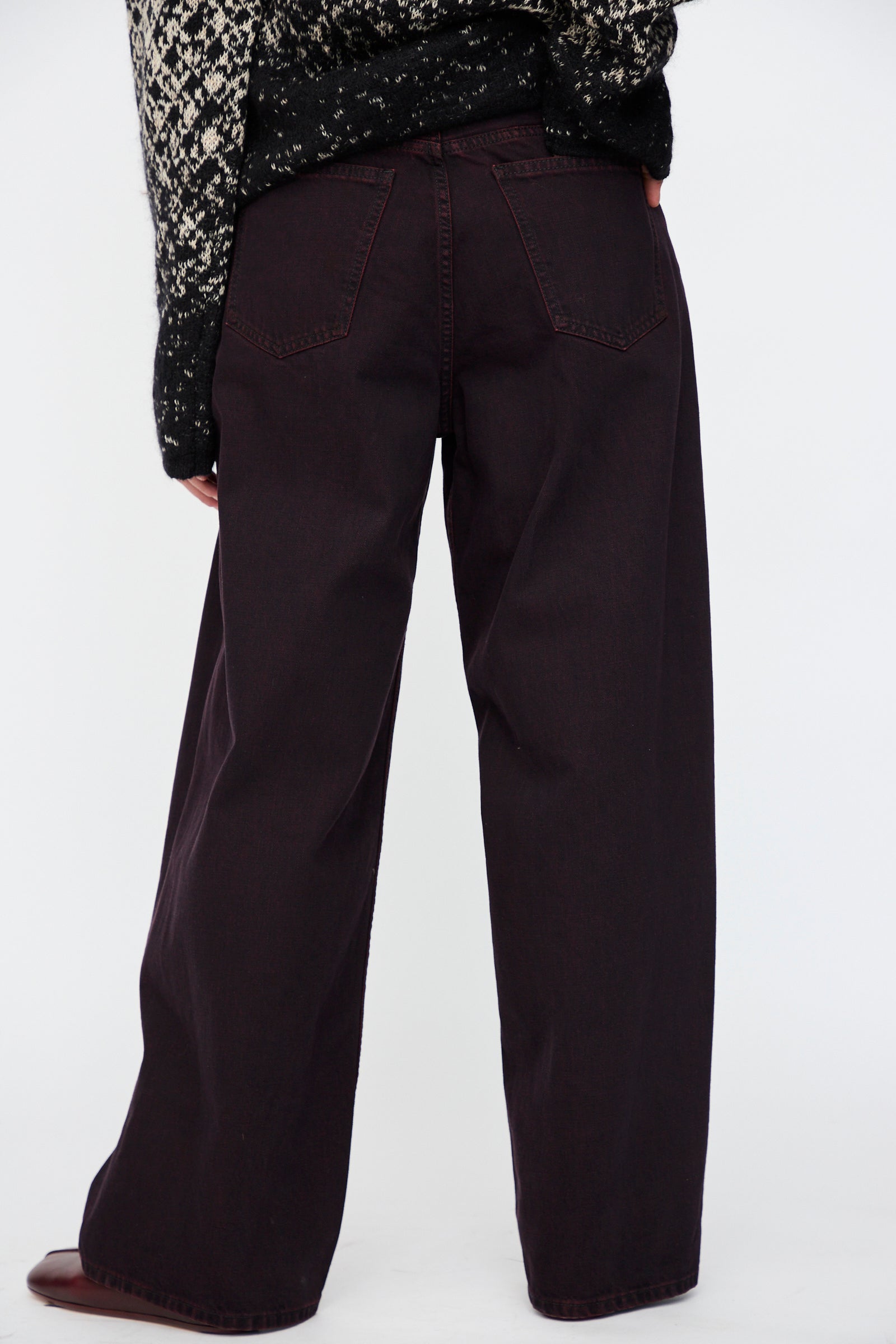 A person wearing MM6 5 Pocket Pants in Burgundy, standing against a plain white background, shown from the back.