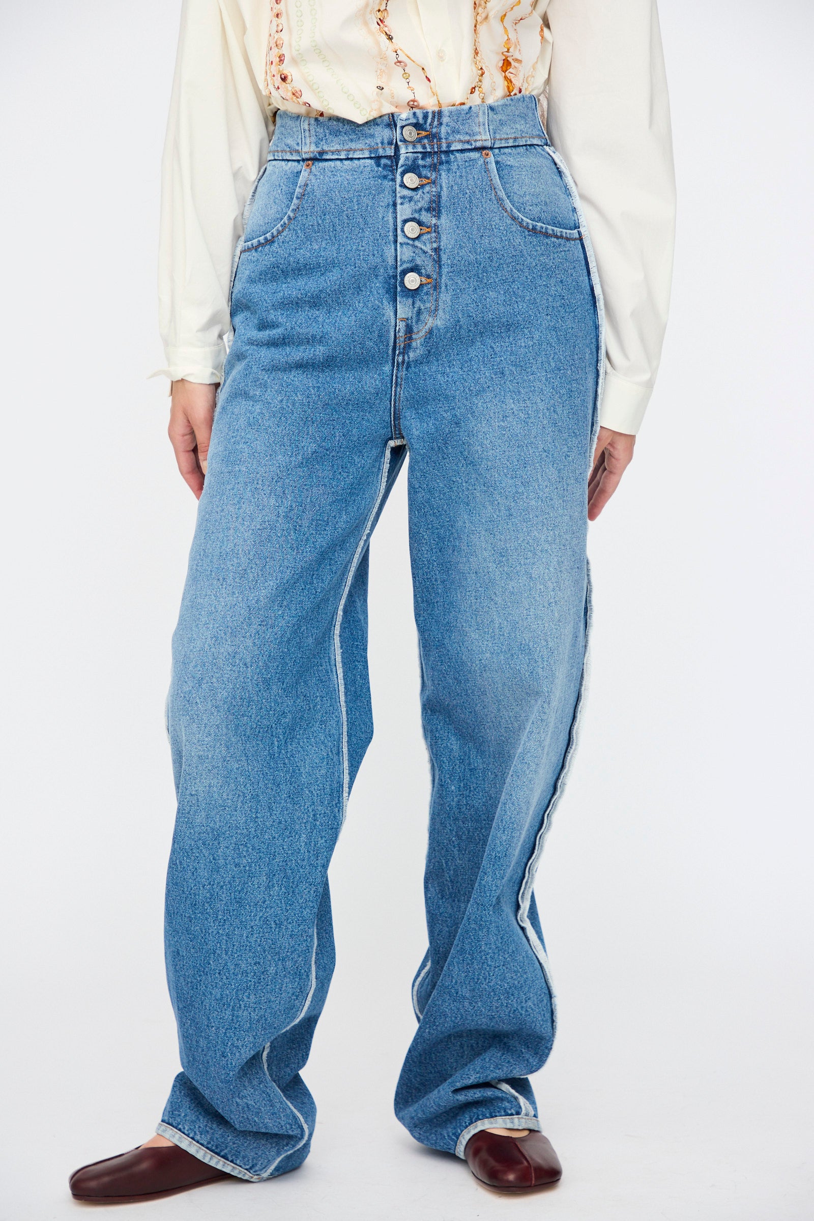 A person wearing MM6 5 Pocket Pants in Medium Blue paired with a cream blouse and dark brown shoes.