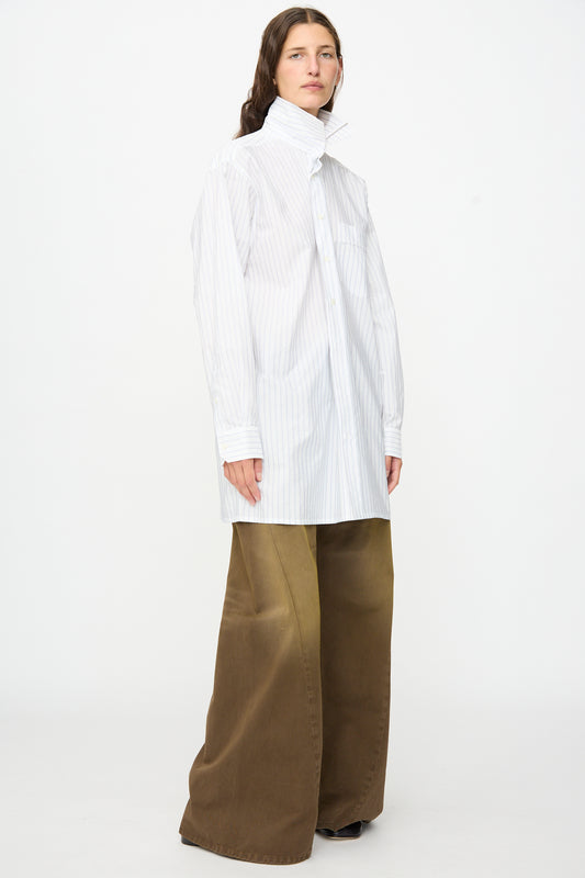A person wearing a white oversized striped button-down shirt and the MM6 5 Pockets Pants in brown, standing against a plain white background.